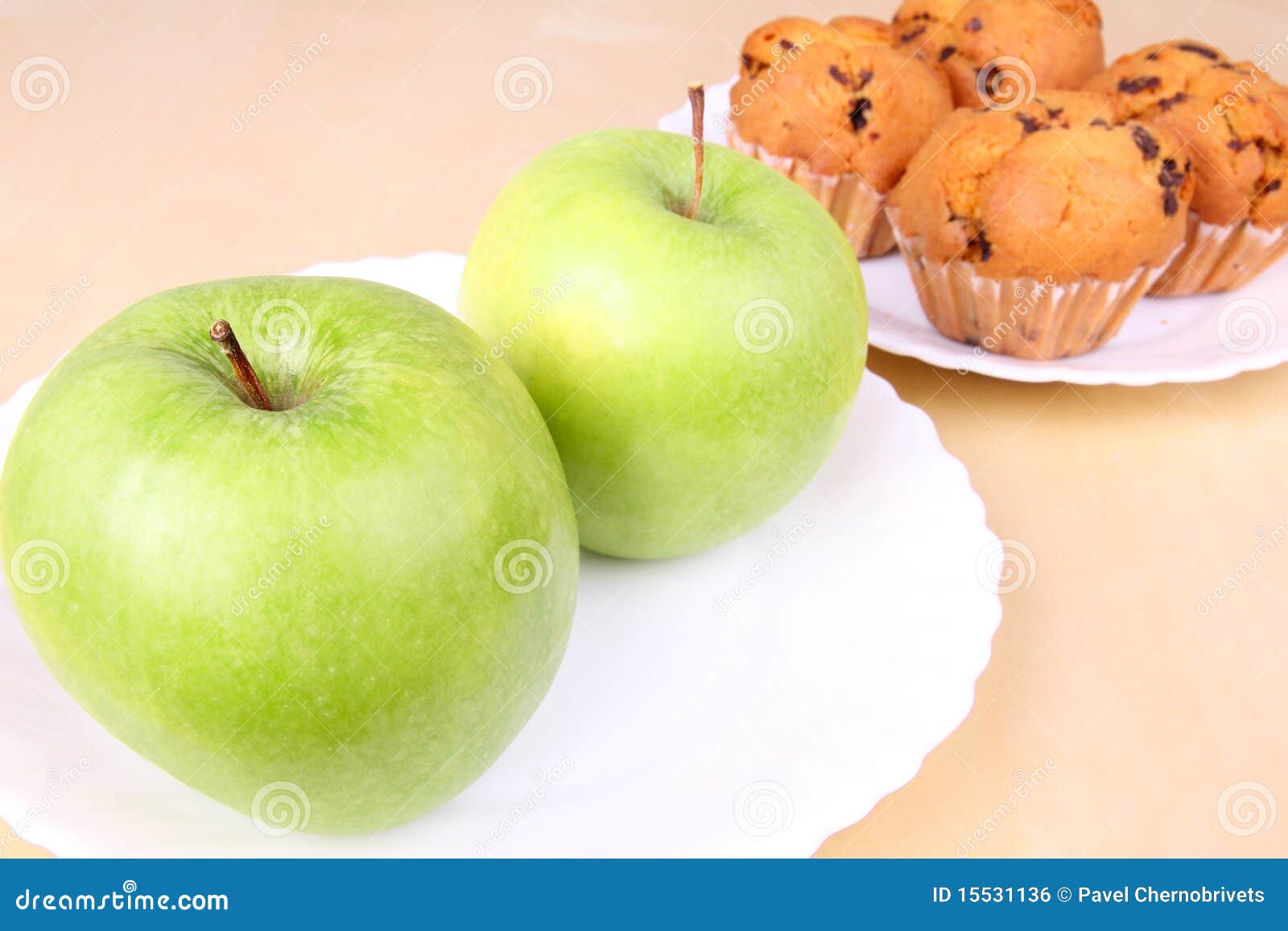 Two apples and cakes on white plates