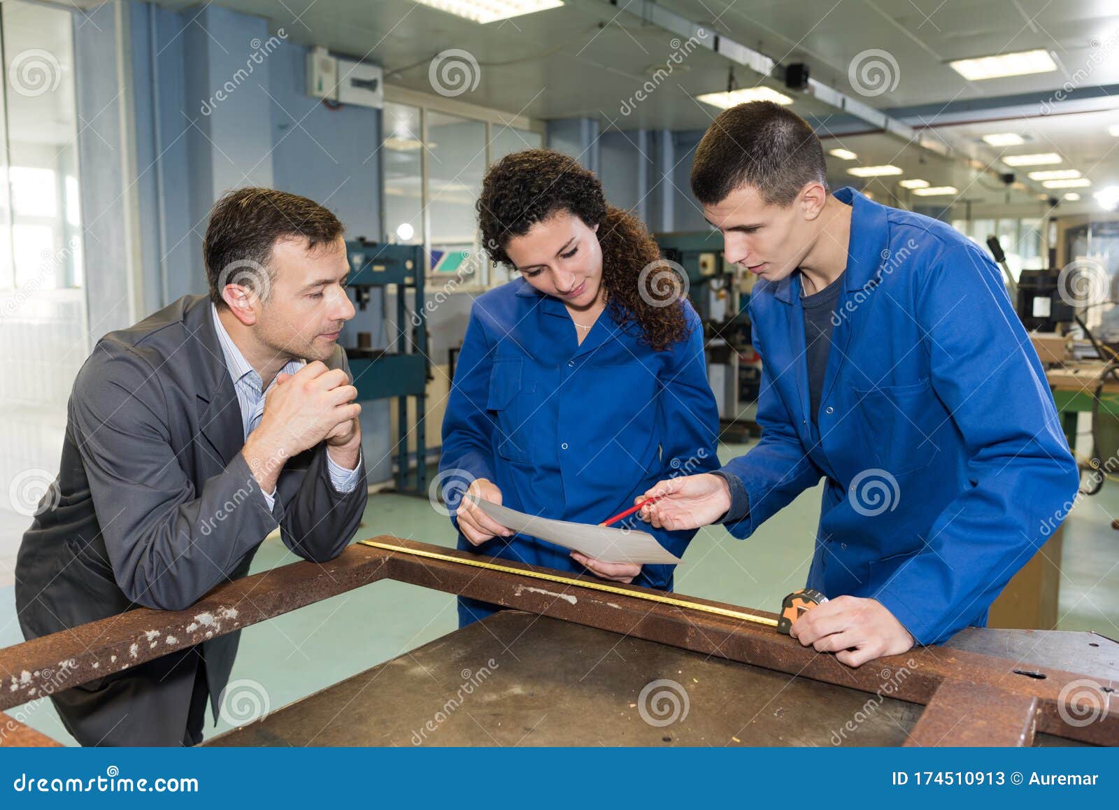 Two Apprentices Doing Furniture Measurement with Client Stock Image