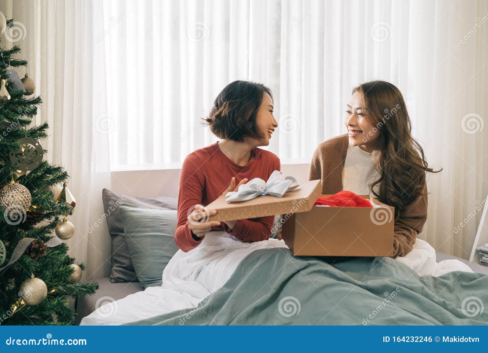 Two Asian Girlfriends Exchanging Christmas Presents Stock Photo