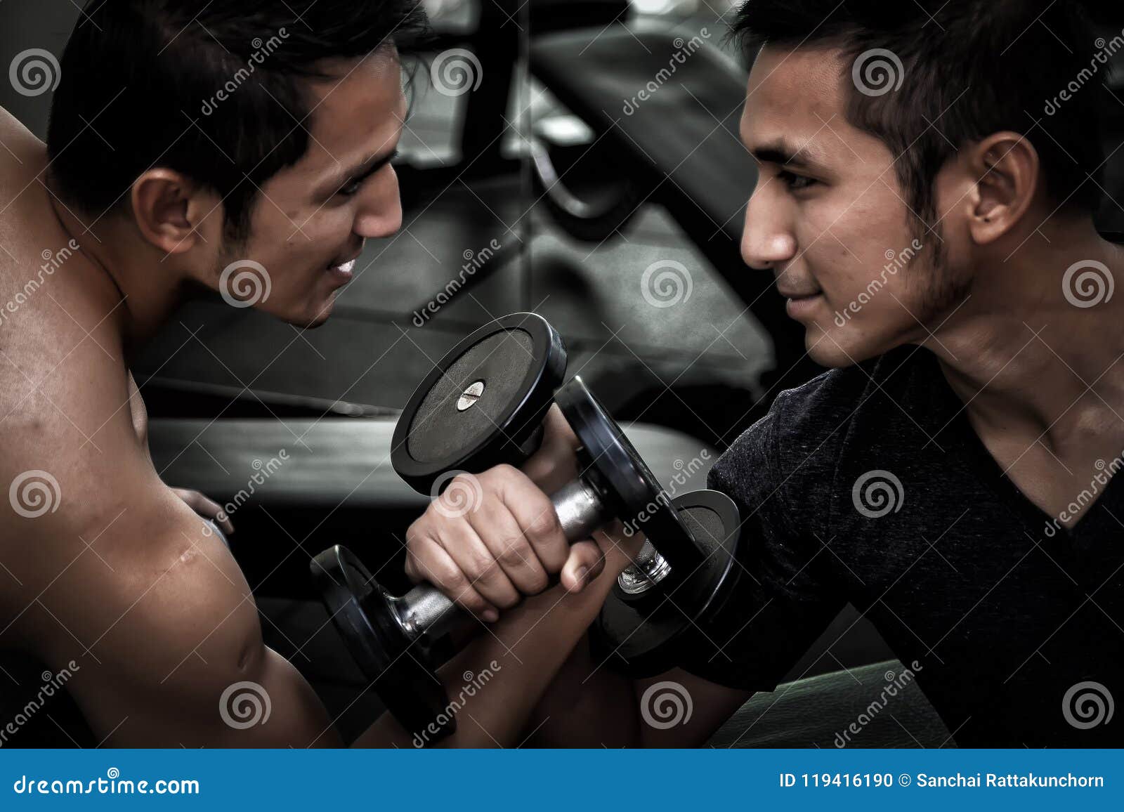 two asian men use dumbbell exercise weight-lifting arm-wrestle c