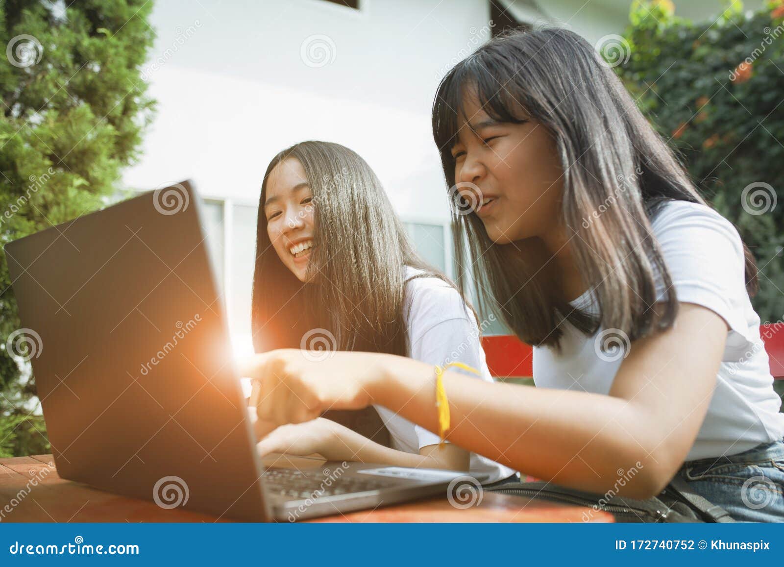 two asian teenager happiness and looking to computer labtop