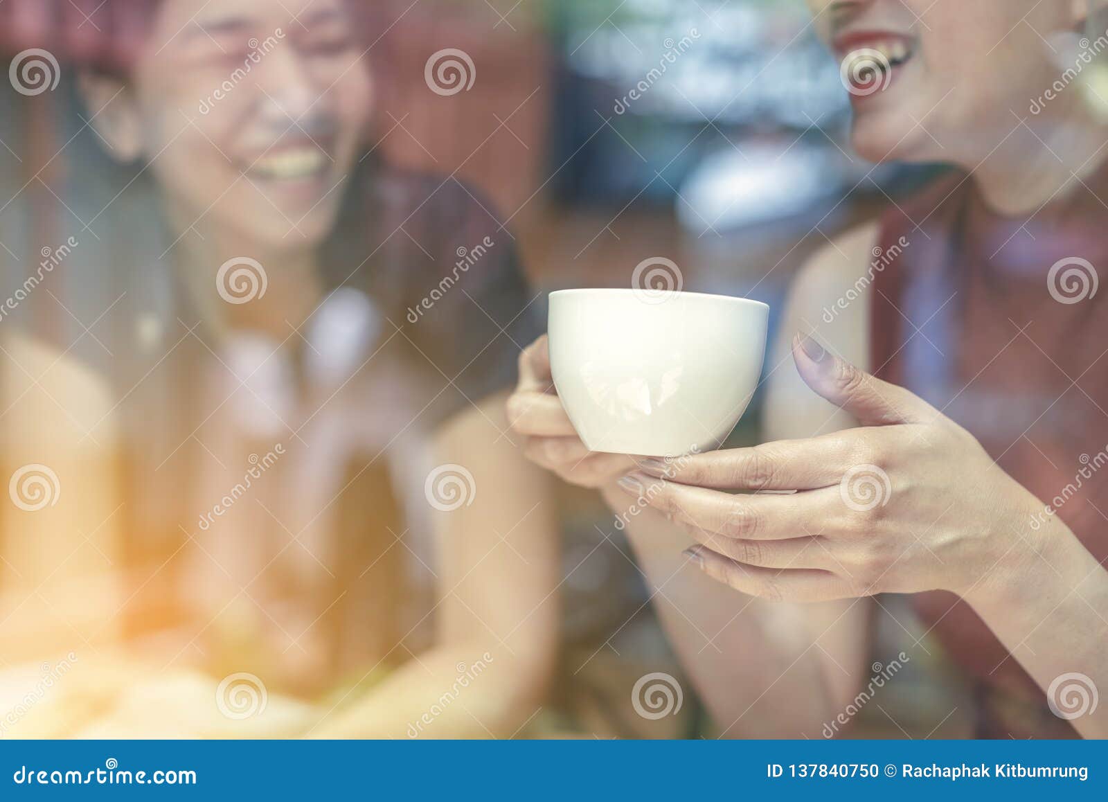 two asian women,friends having a free time drinking coffee at cafe. friends laughing together while drinking a coffee in the resta