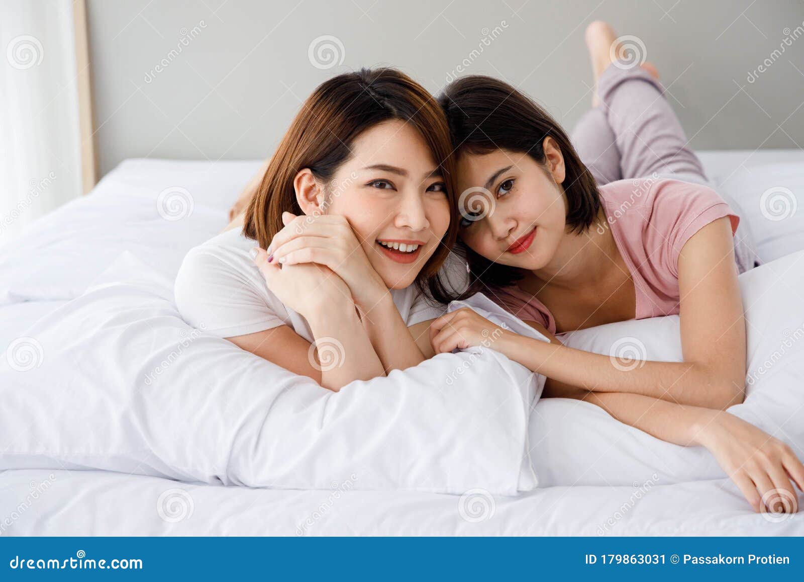 Two Asian Women Lie Down On Bed Together Stock Image Image Of