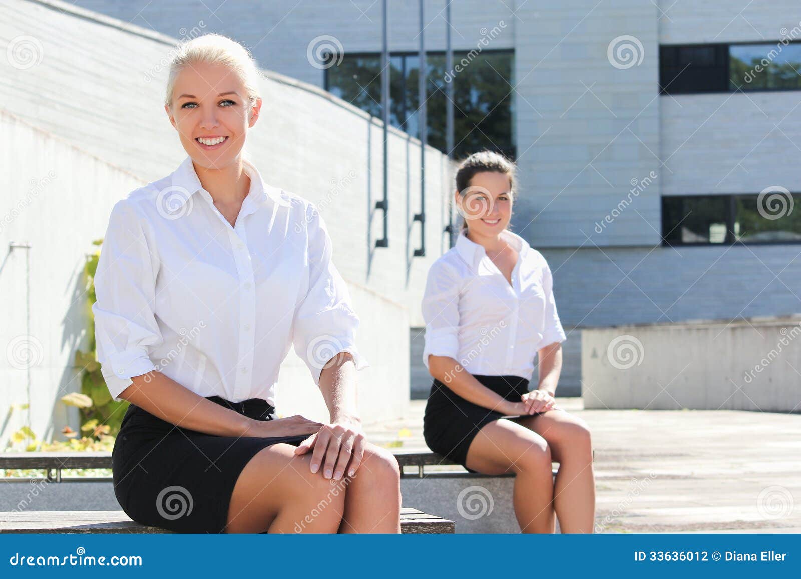 Two Attractive Business Women Sitting Over Street Background Stock ...
