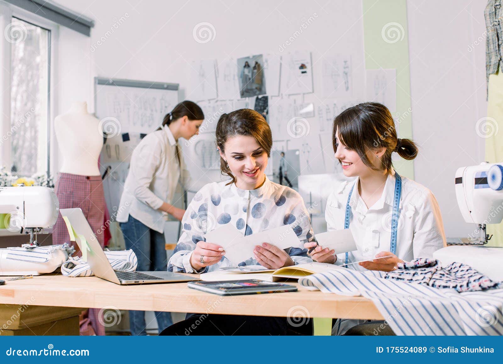 Two Attractive Women Dressmakers Designers Choosing Trendy Sketches and ...