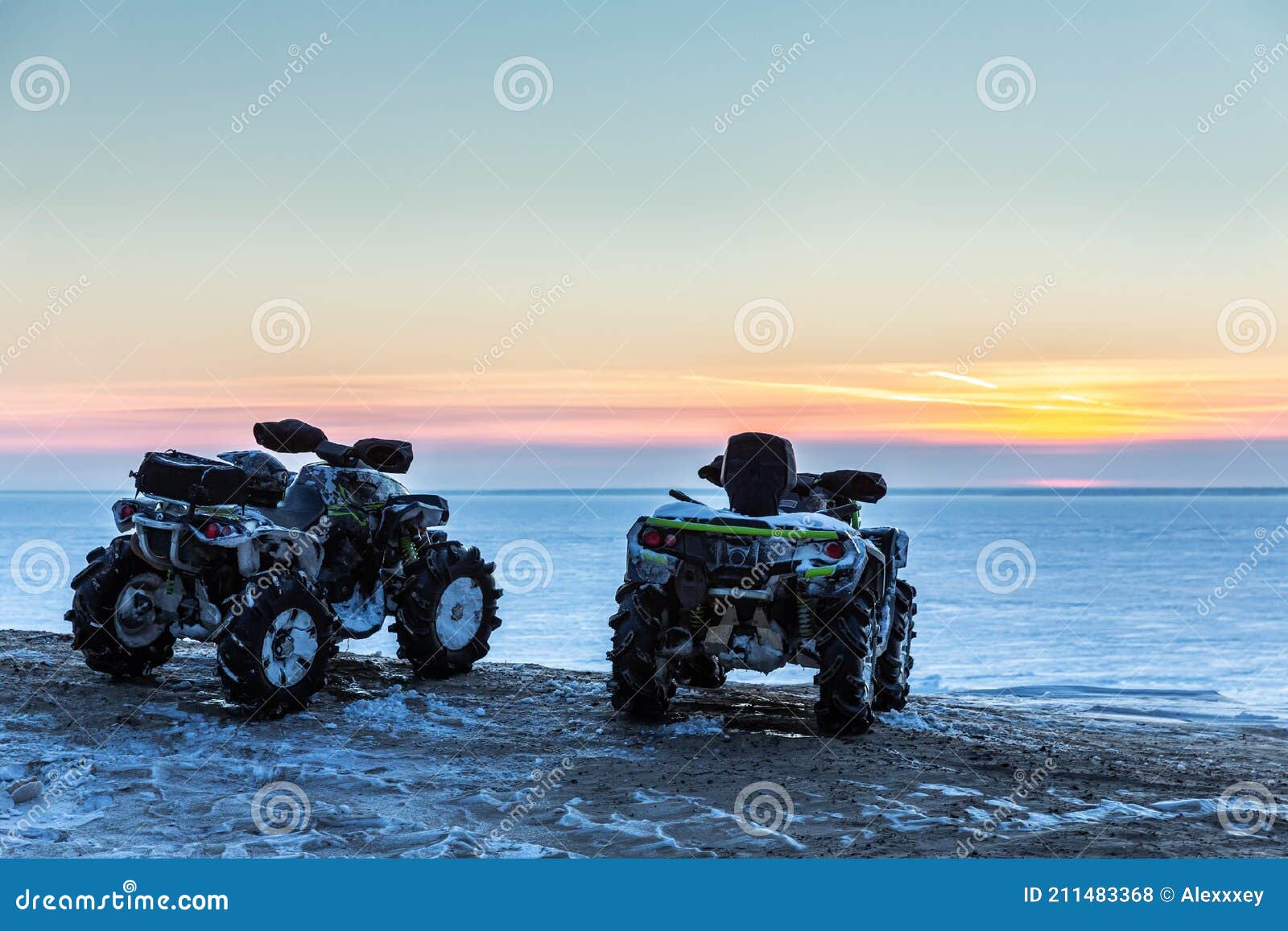 Two ATVs at Sunset Over the Frozen North Sea Stock Photo Image of