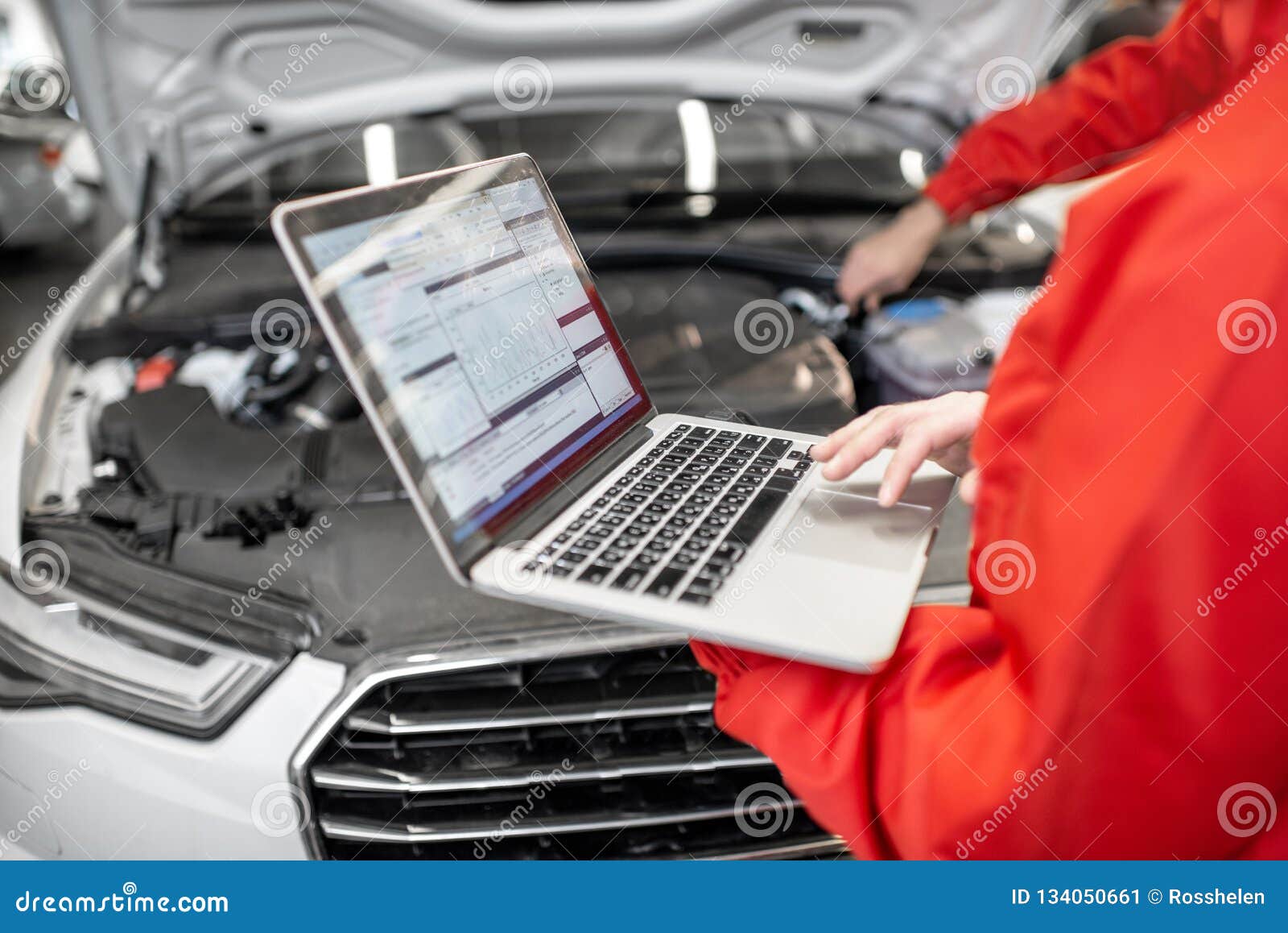 auto mechanics doing diagnostics with laptop