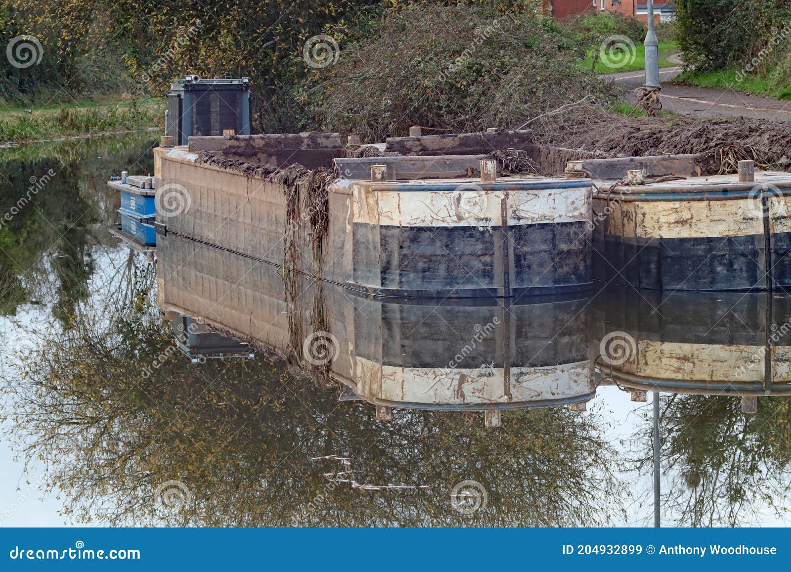 Two Barges Moored on a Murky Canal in England, Filled with Mud from a