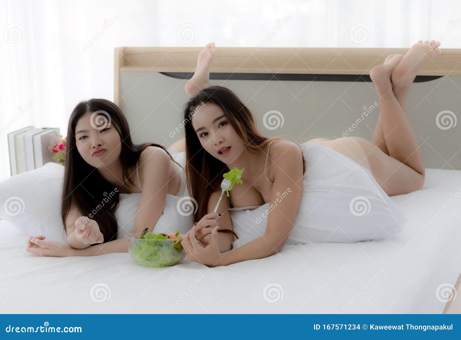 1600px x 1180px - Two Beautiful Asian Women in a Sheer Costume Lie on a White Couch Eating  Healthy Food. a Young Woman Holding a Small Party Stock Photo - Image of  bedroom, korean: 167571234