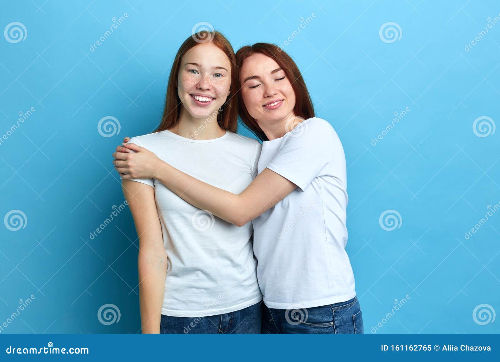 Two Beautiful Best Friends Hugging While Standing In The Studio Stock