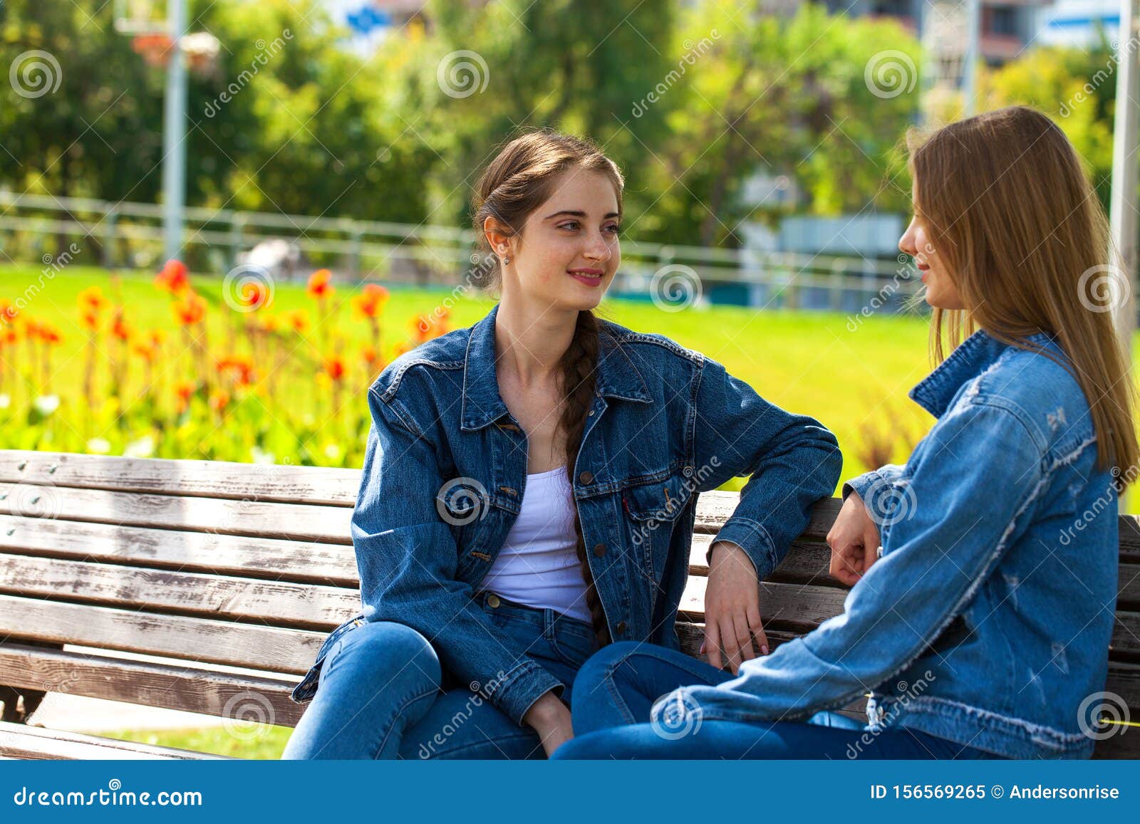 Two Beautiful Girlfriends Are Talking In A Park Sitting On A Bench Stock Image Image Of