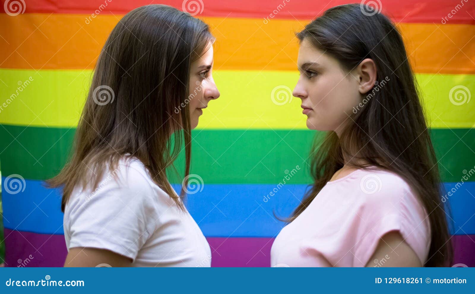 Two Beautiful Lesbians Standing On Rainbow Flag Background Minority