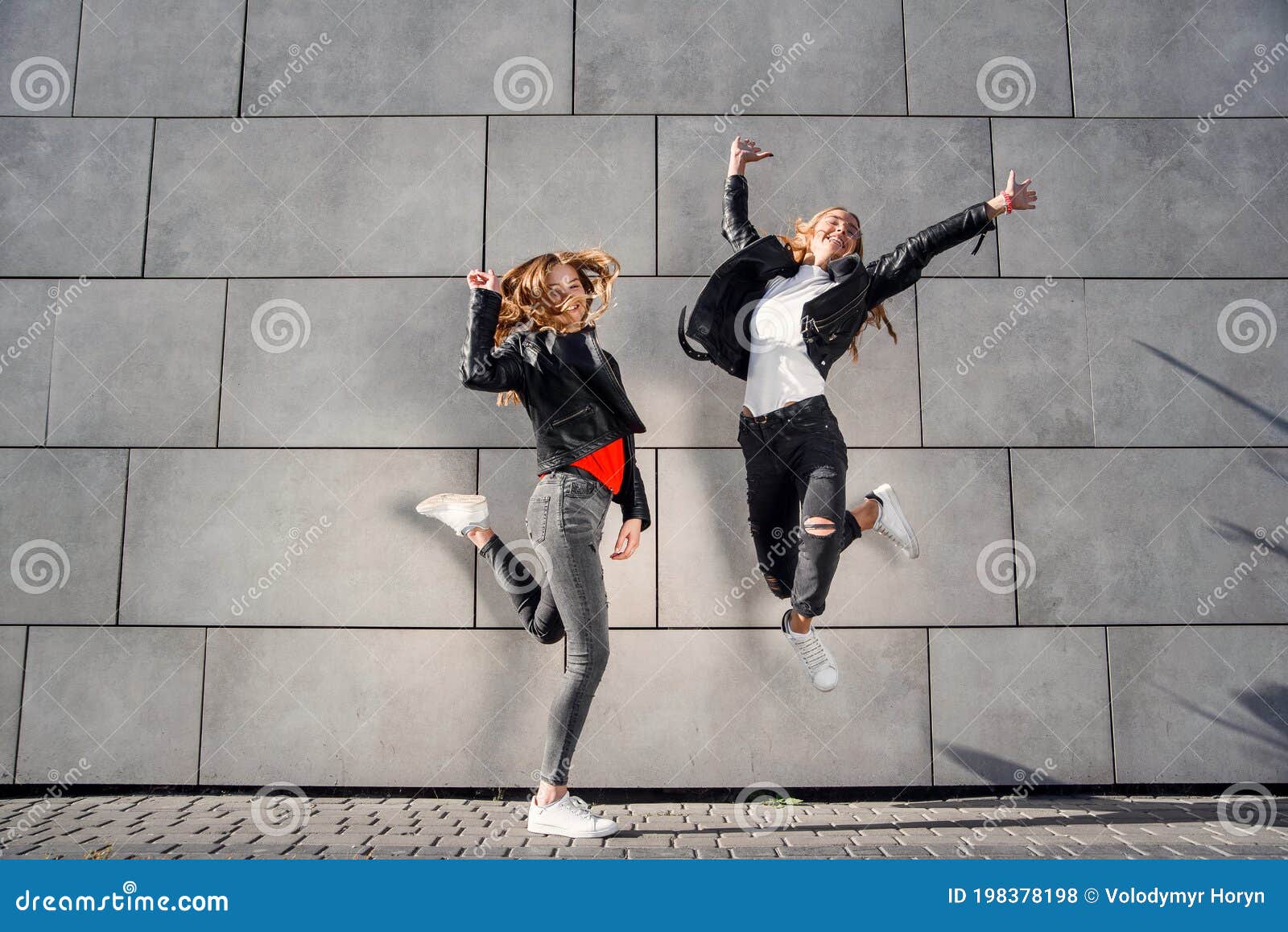 Two Beautiful Teenage Girlfriends Jump and Having Fun Near Grey ...