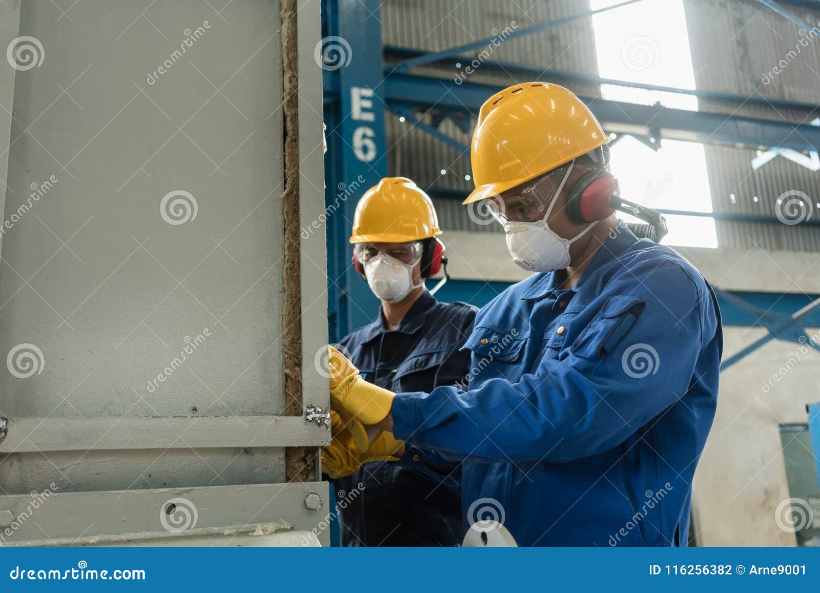 two blue-collar workers wearing protective equipment