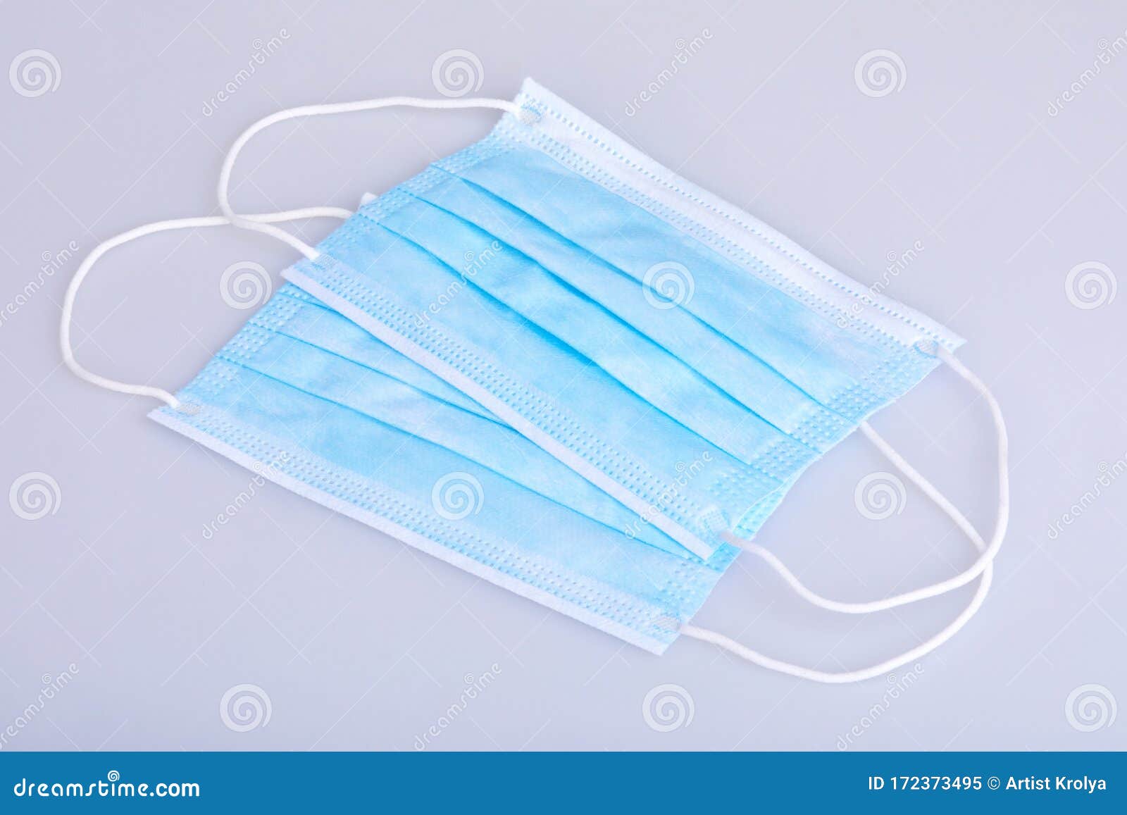 two blue disposable face masks on white background.