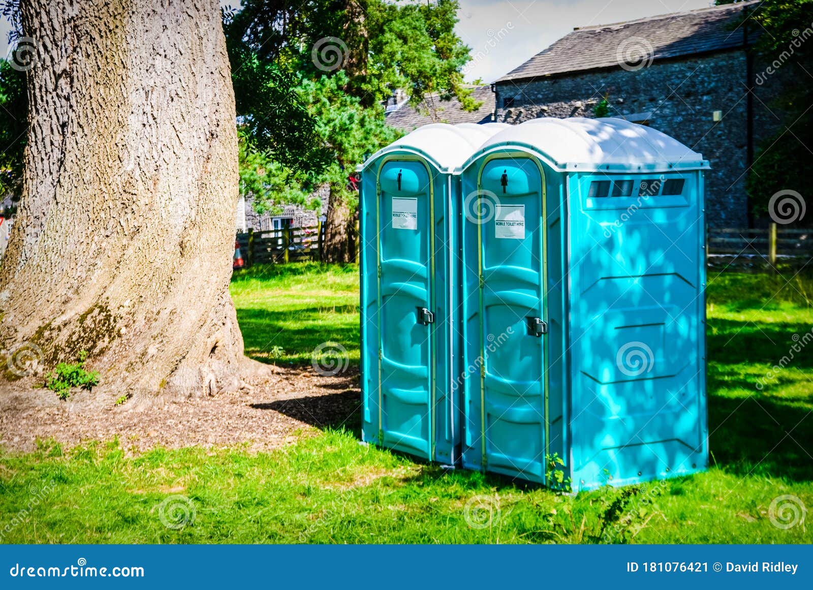 two blue - white portable toilet cabins at outside event uk