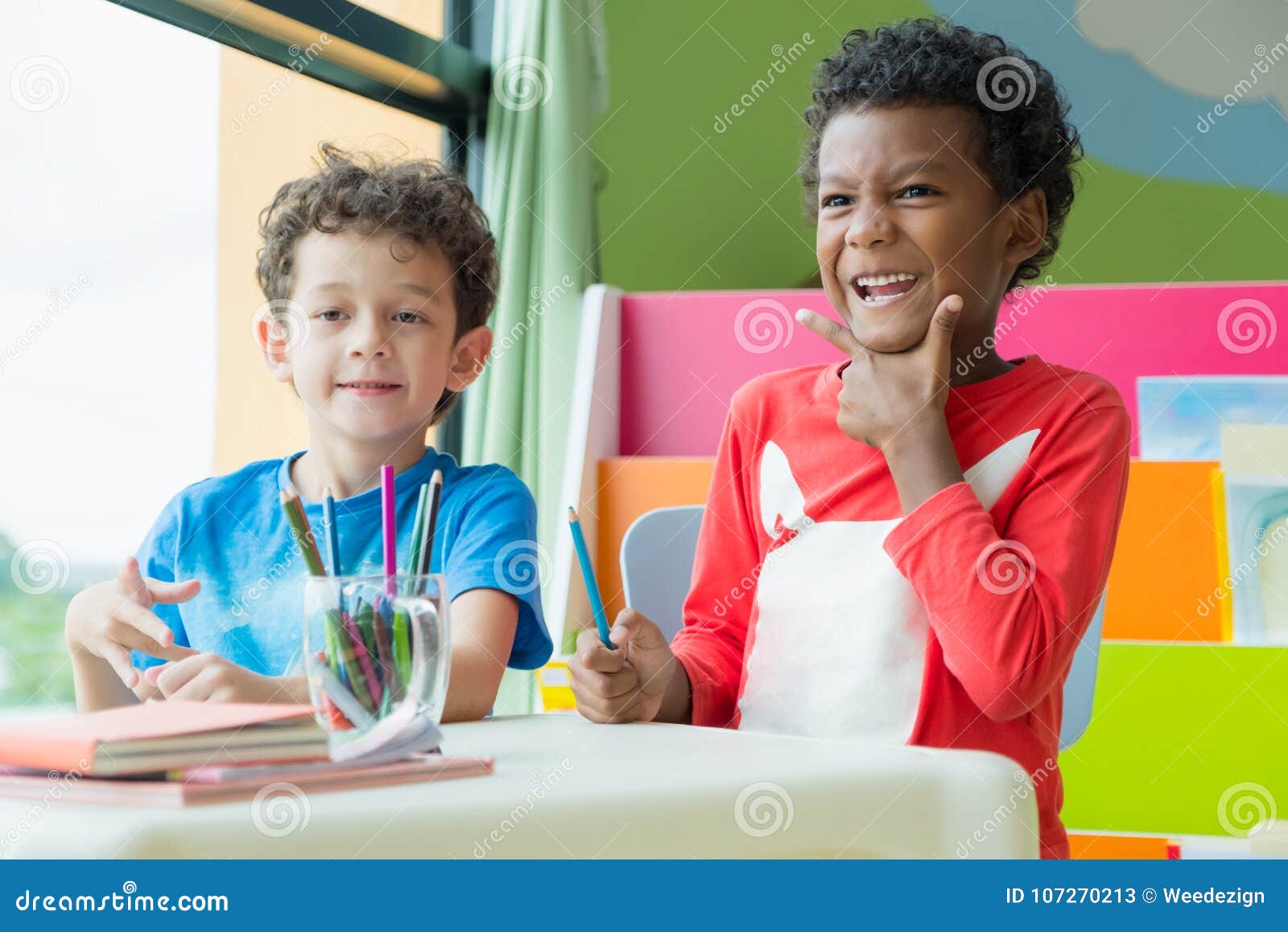 Two Boy Kid Sit On Table And Coloring In Book In Preschool Libr