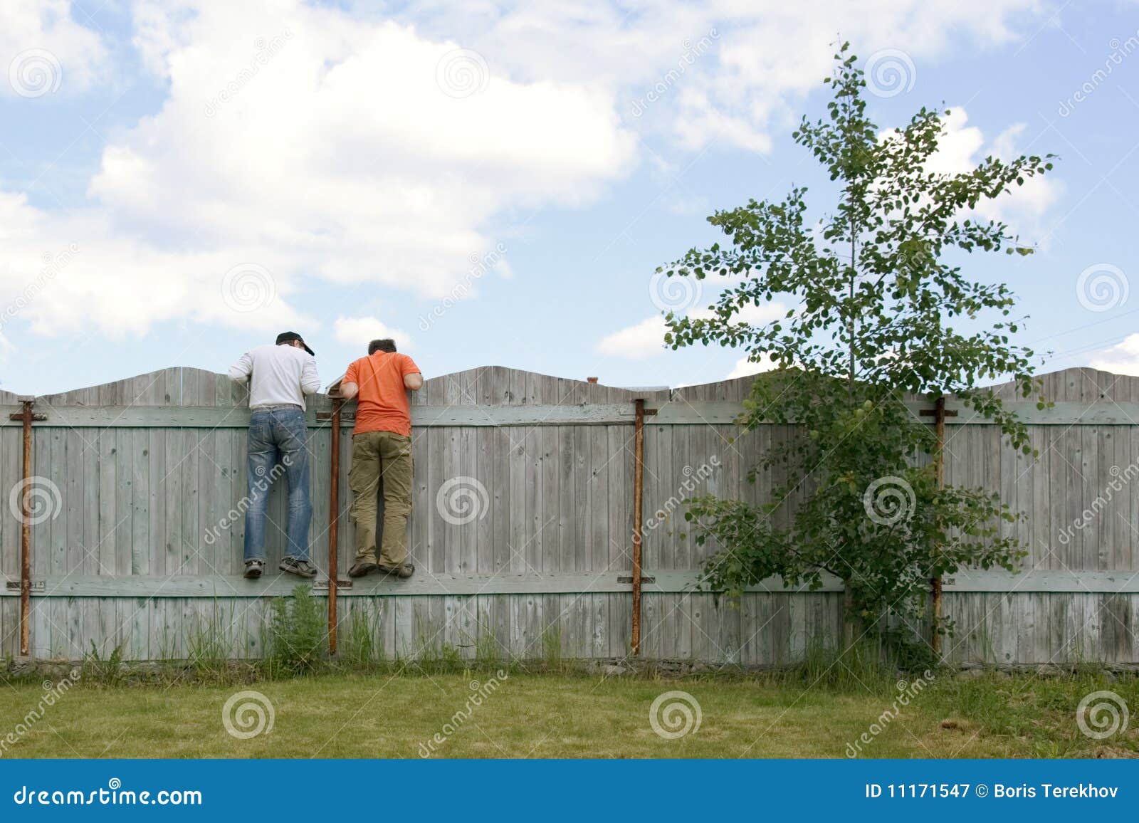 two boys on the fence looking for smth