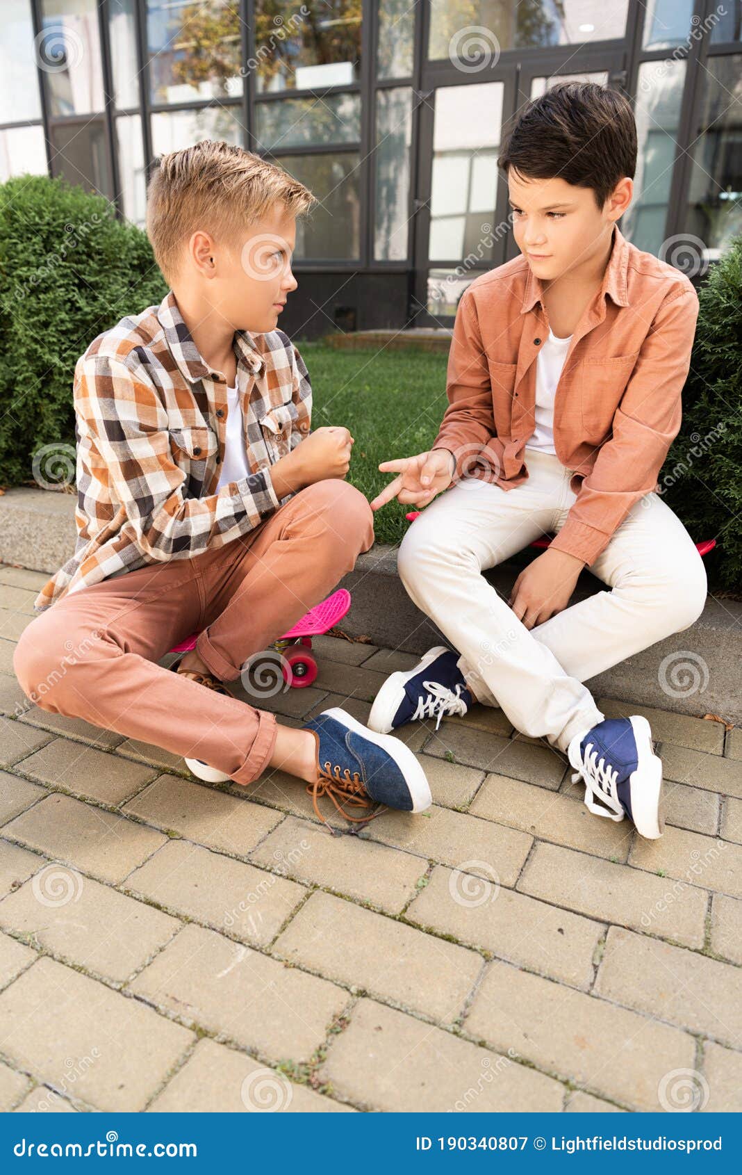 Two Brothers Playing in Rockpaperscissors Game while Sitting Stock