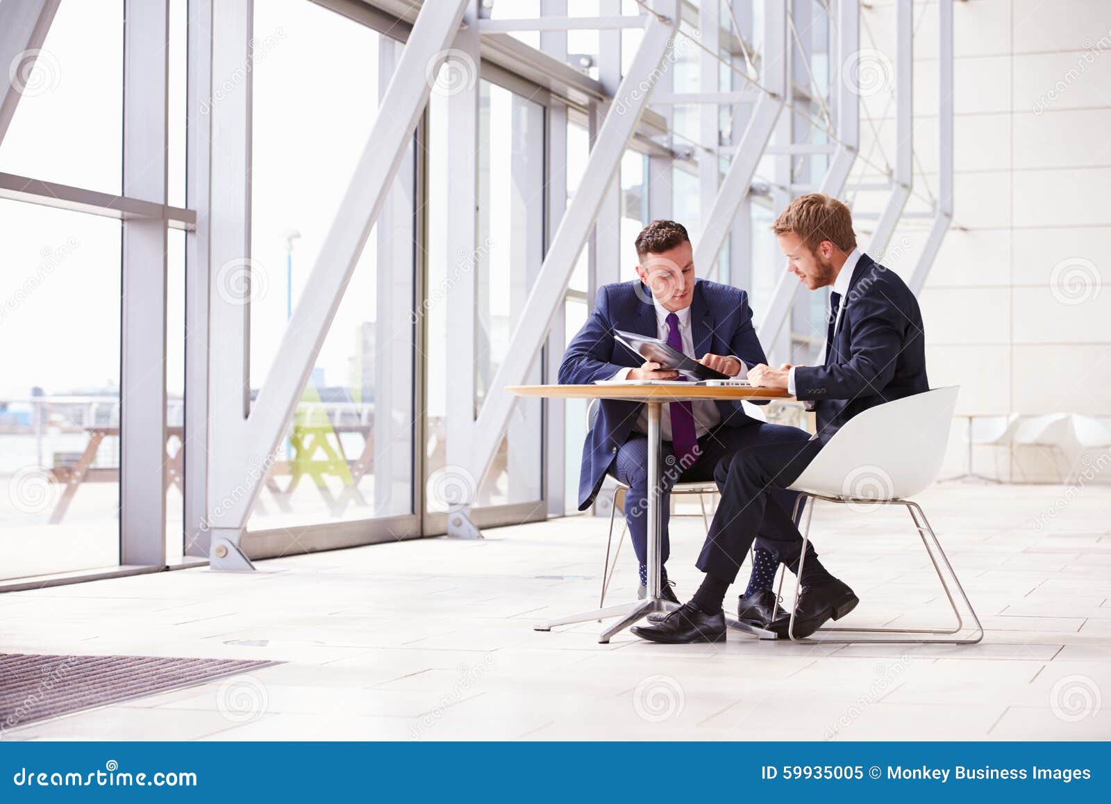 two business colleagues at meeting in modern office interior
