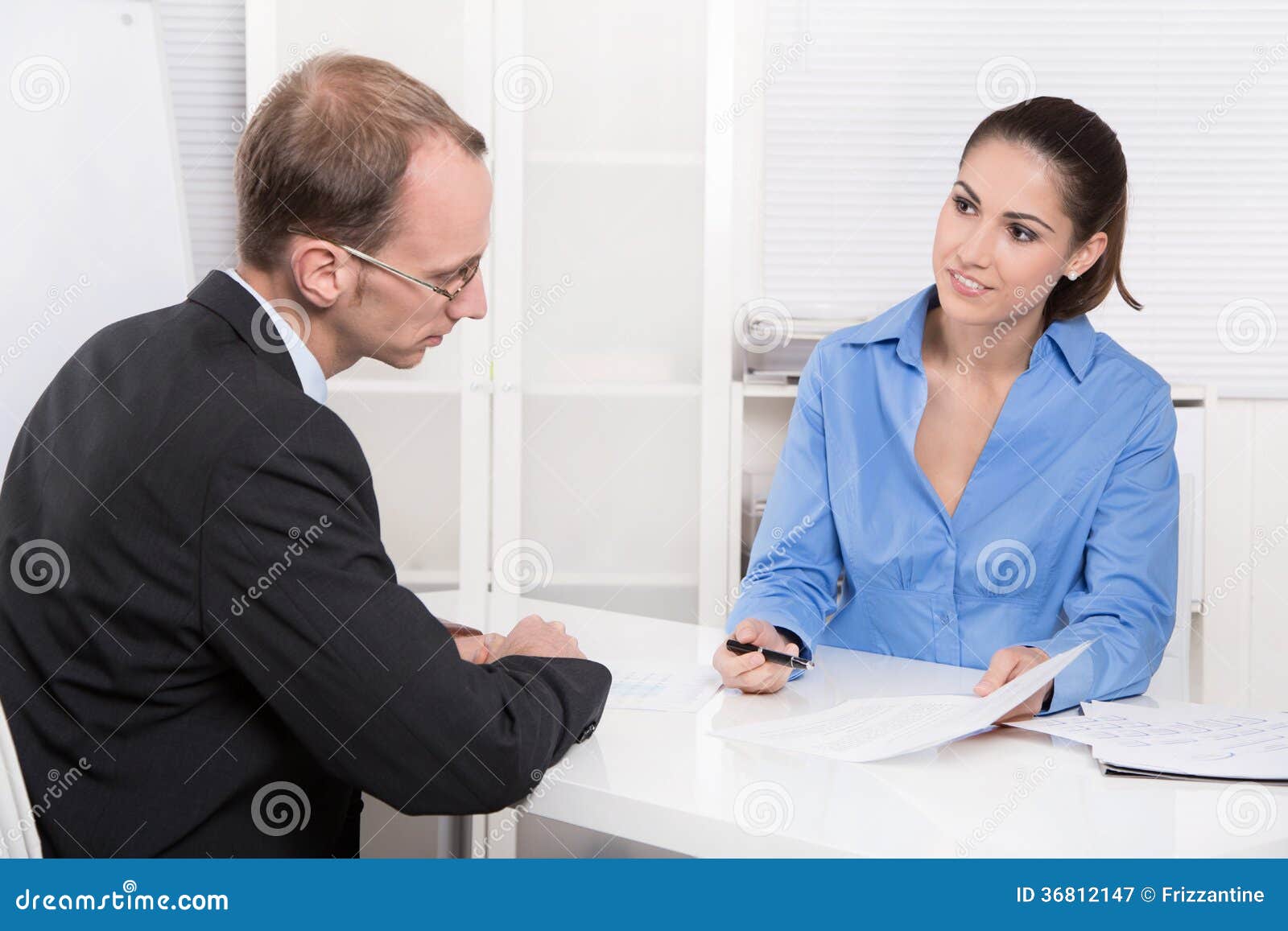 two business people talking together at desk - adviser and customer