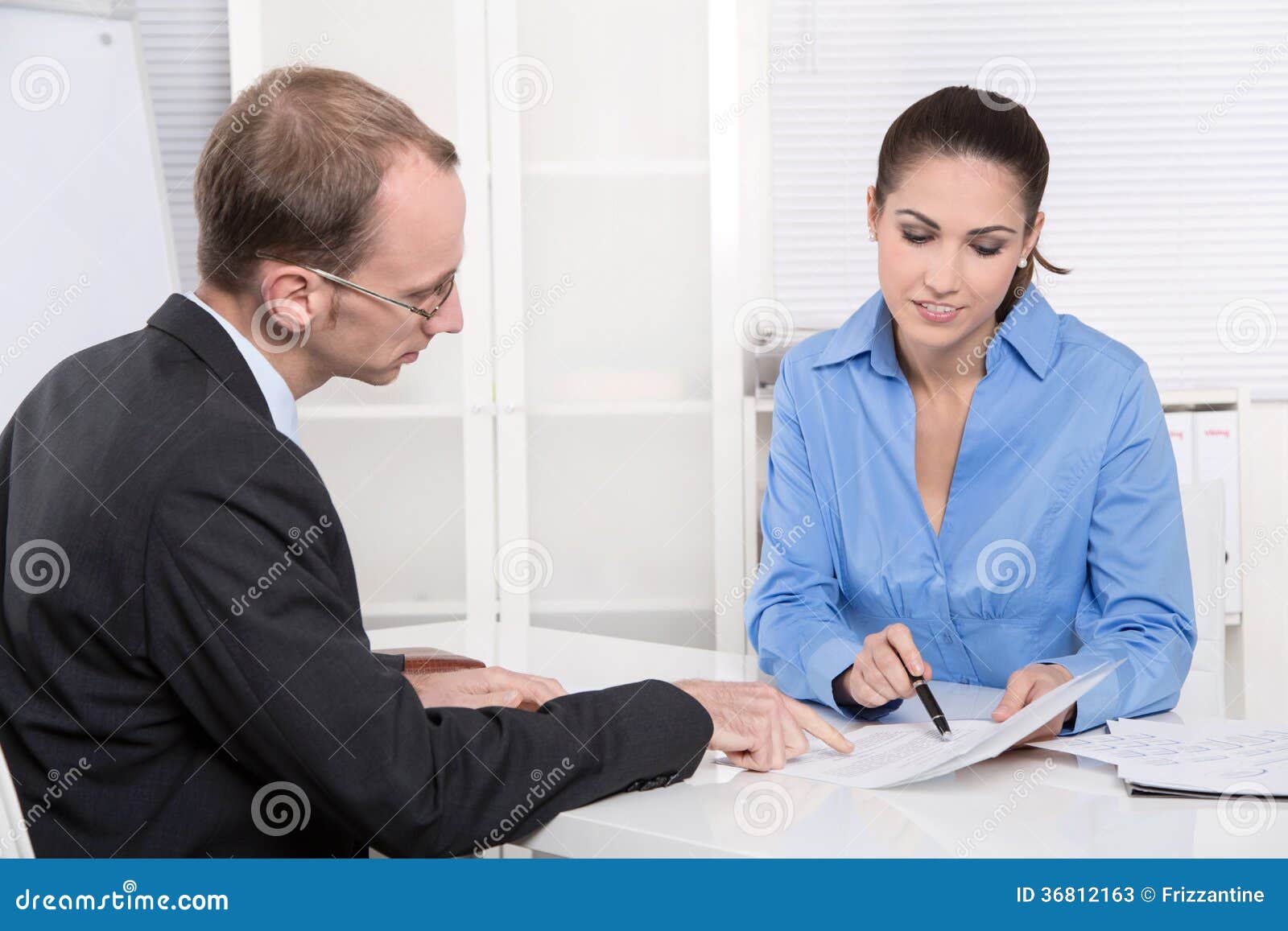 two business people talking together at desk - adviser and customer