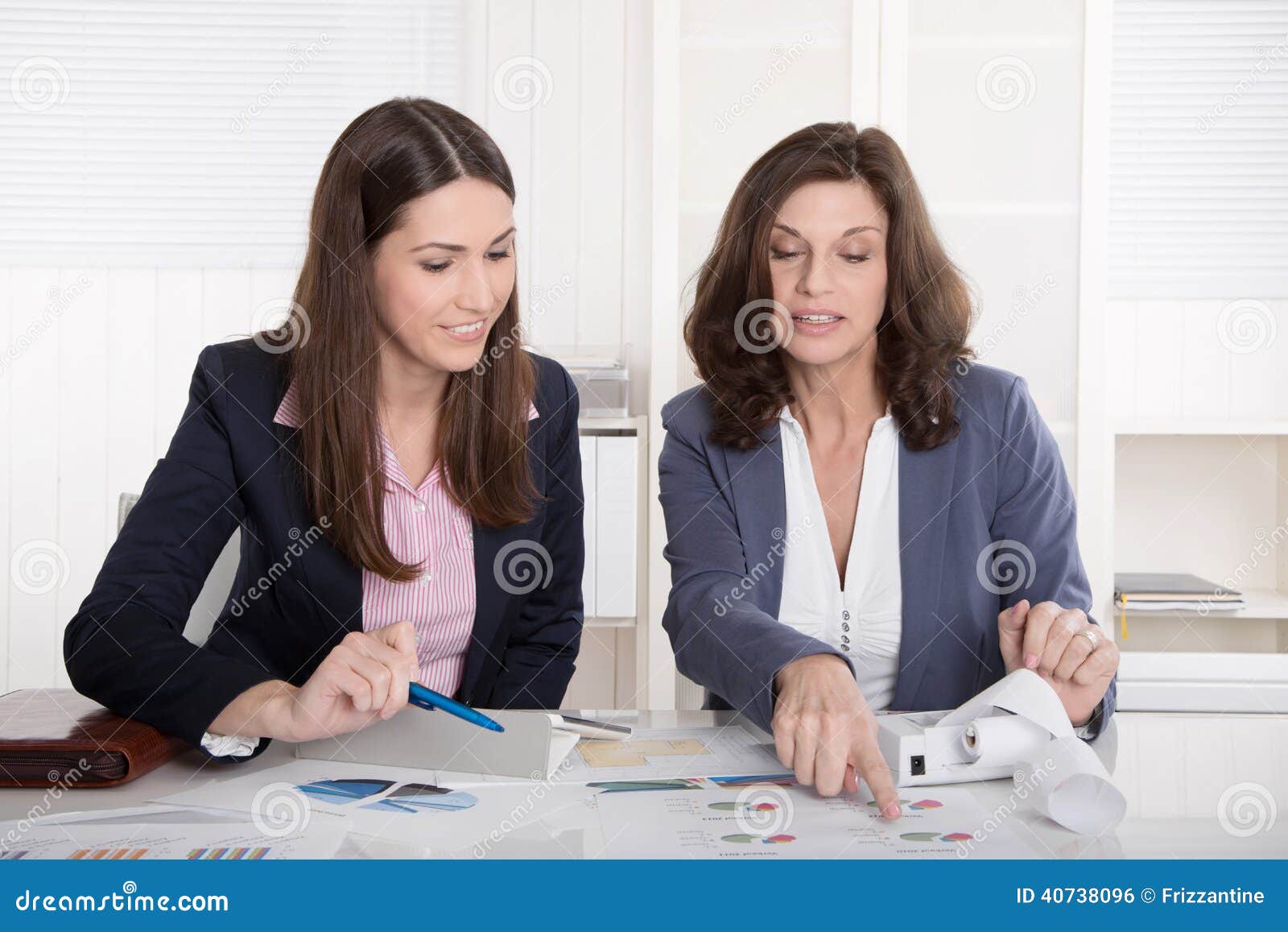 two business woman analyzing balance sheet.