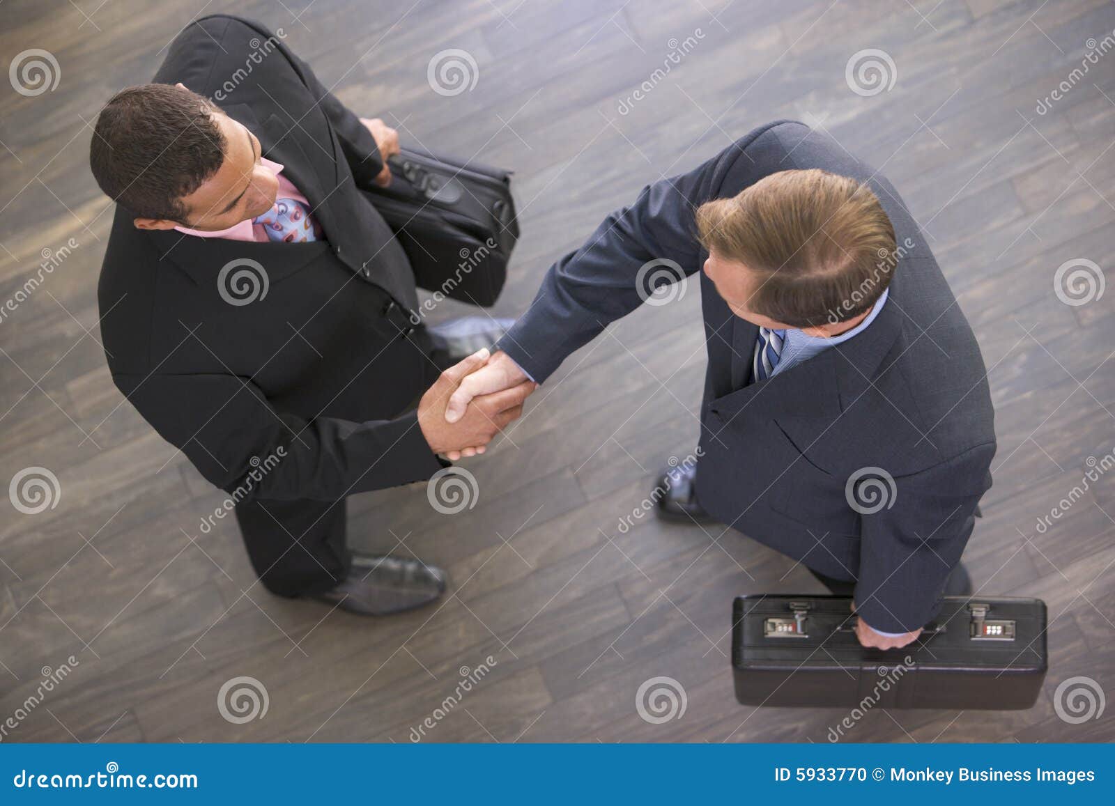 two businessmen indoors shaking hands