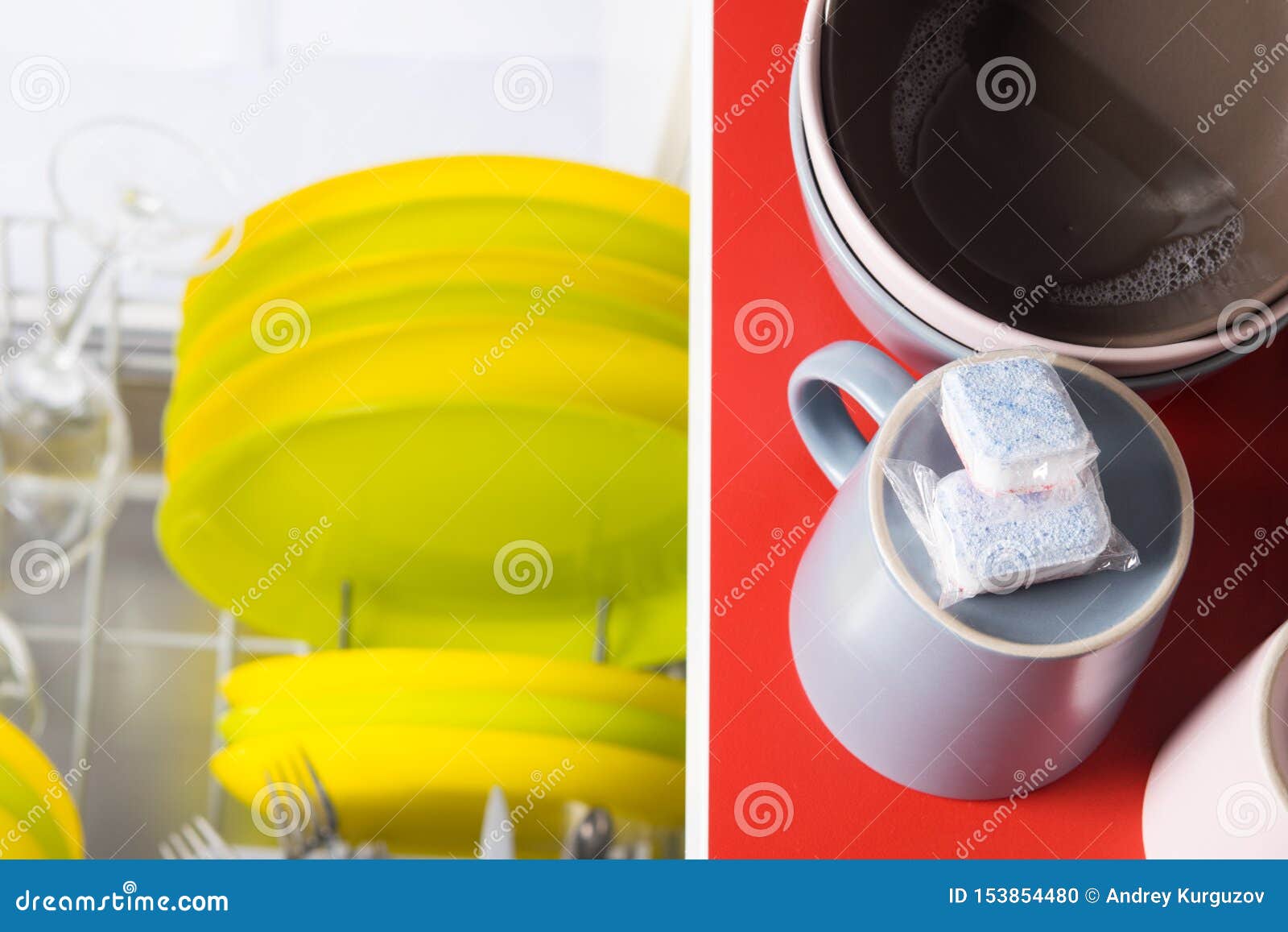 Two Capsules for Cleaning from Fat, Lie on Dirty Mugs, on the Table