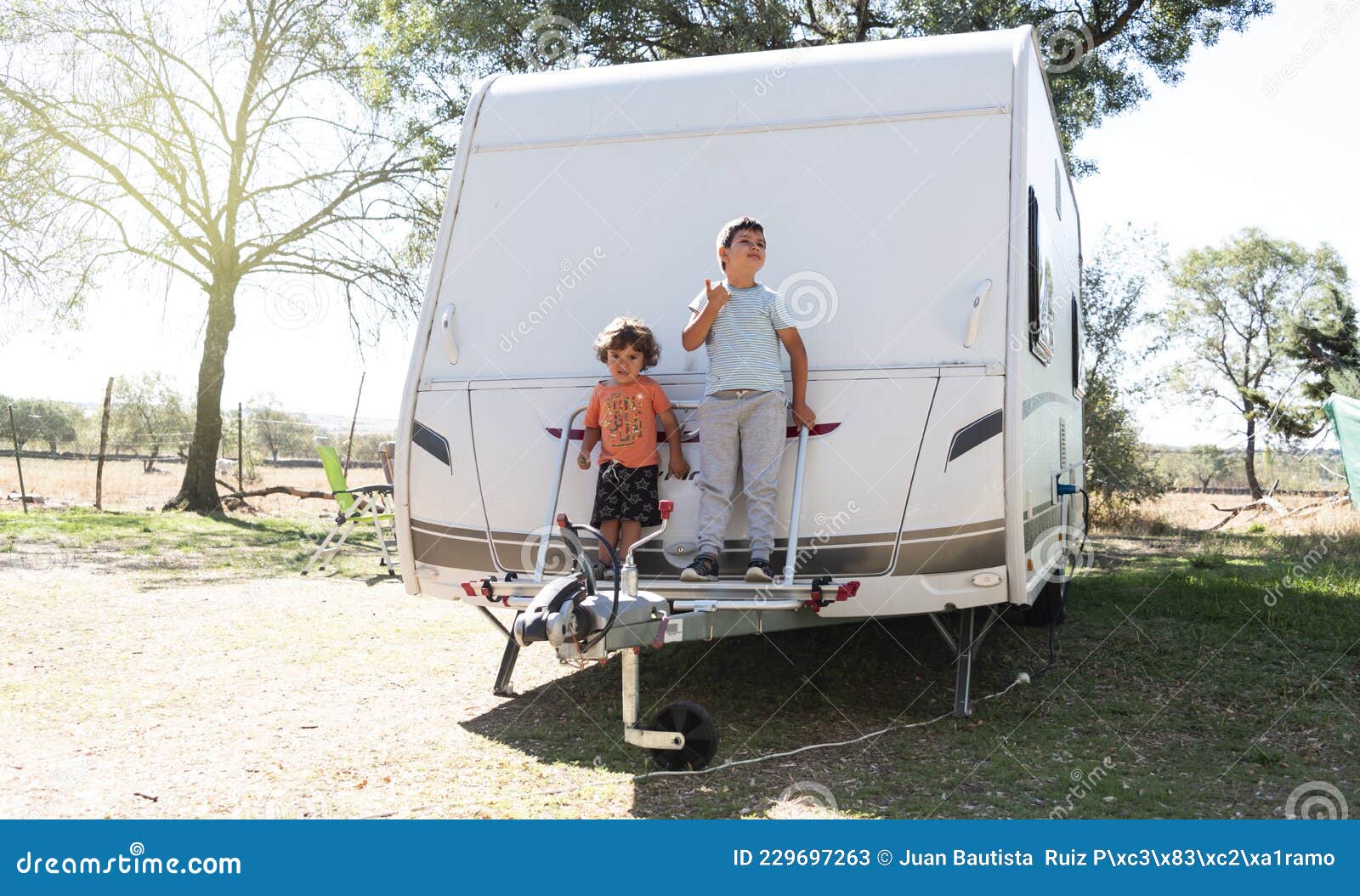 Two Caucasian Children Play and Spend Alternative Holidays in a Caravan