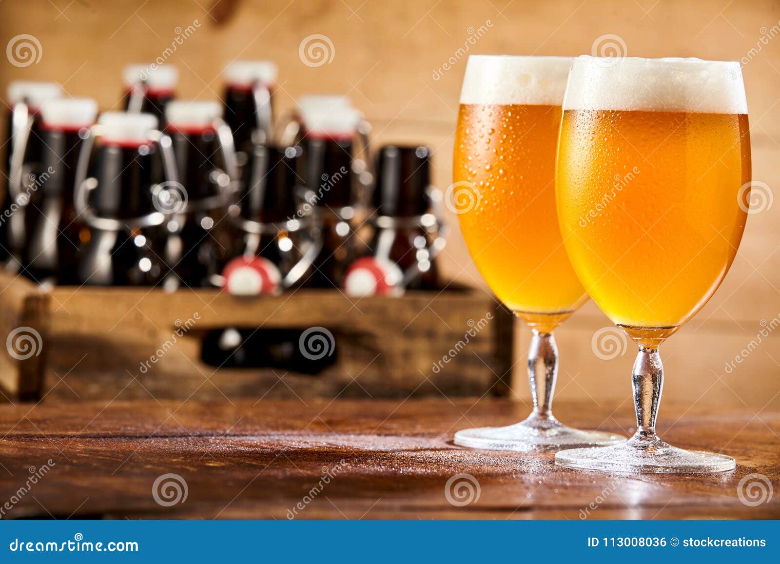 Two Chalices of Pale Beer Against Box with Bottles Stock Photo Image