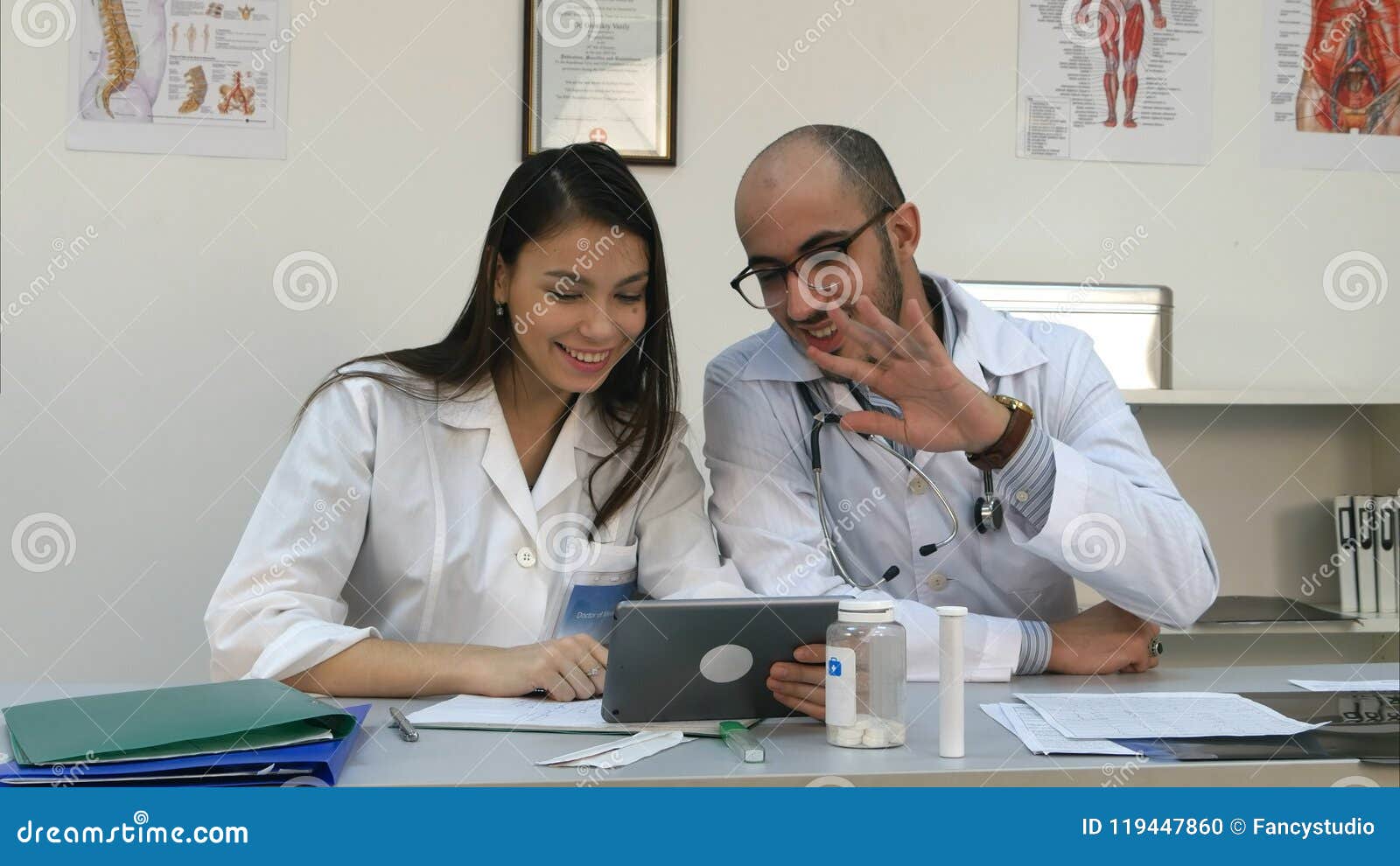 Two Cheerful Doctors Having Positive Video Call Via Tablet Stock Photo