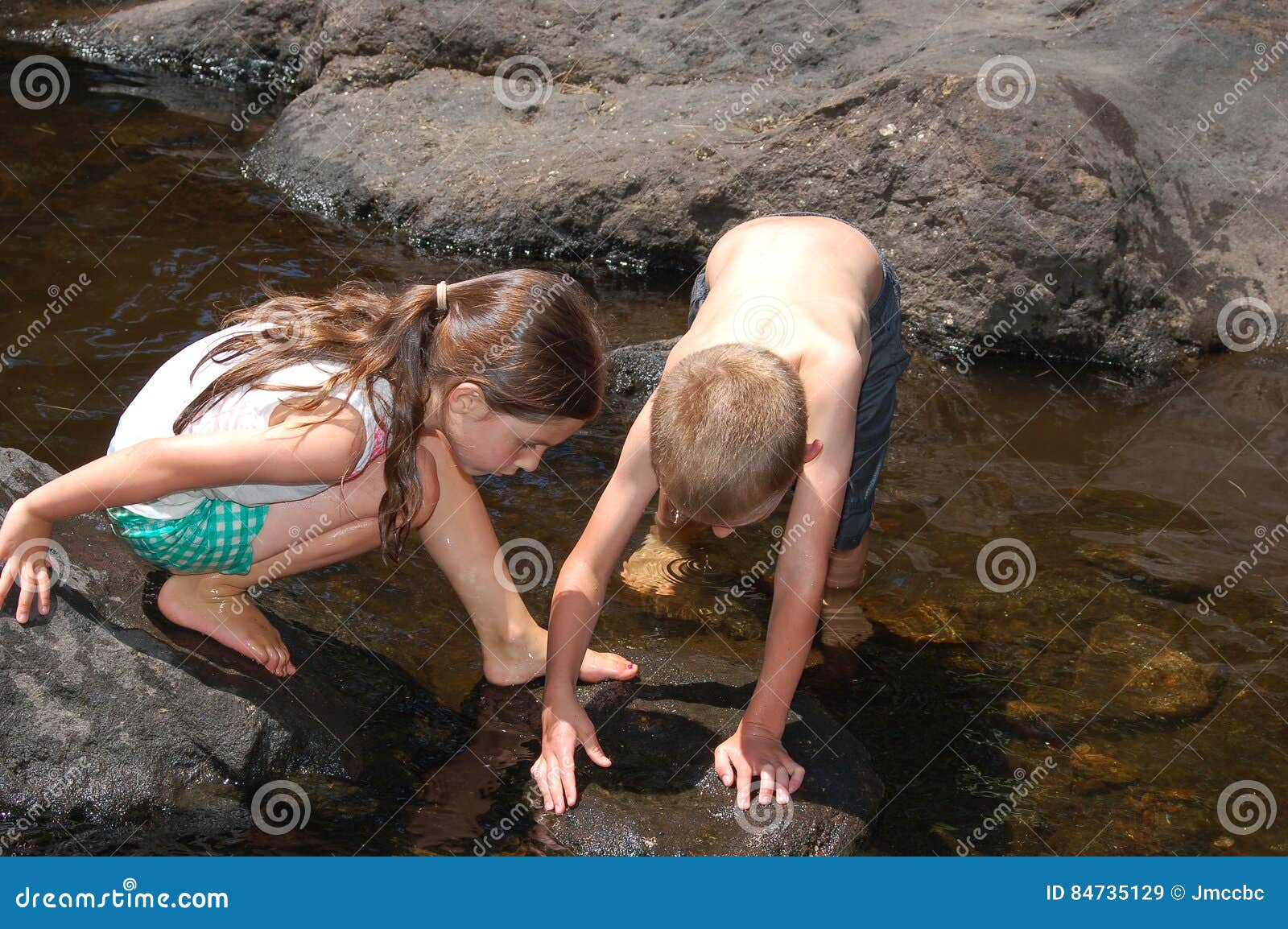 two children exploring nature in the brook