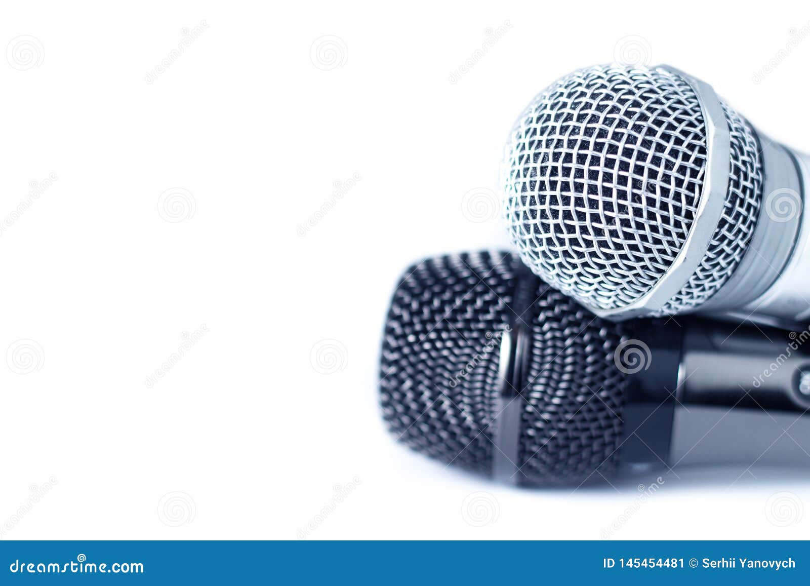 two close-up of microphones on white background with copy space, selective focus