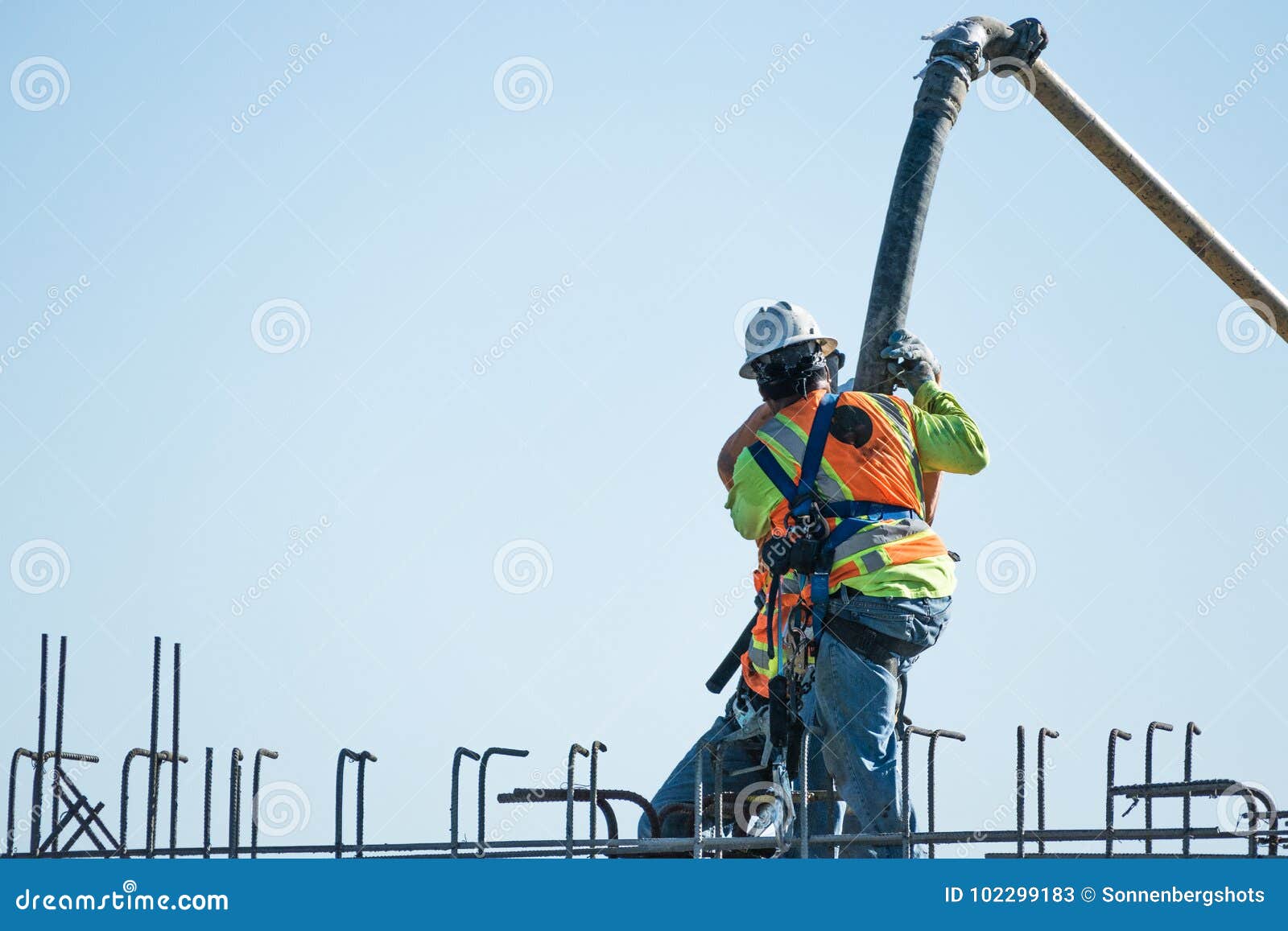 Two Construction Workers Pour Cement in Rebar Editorial Stock Photo