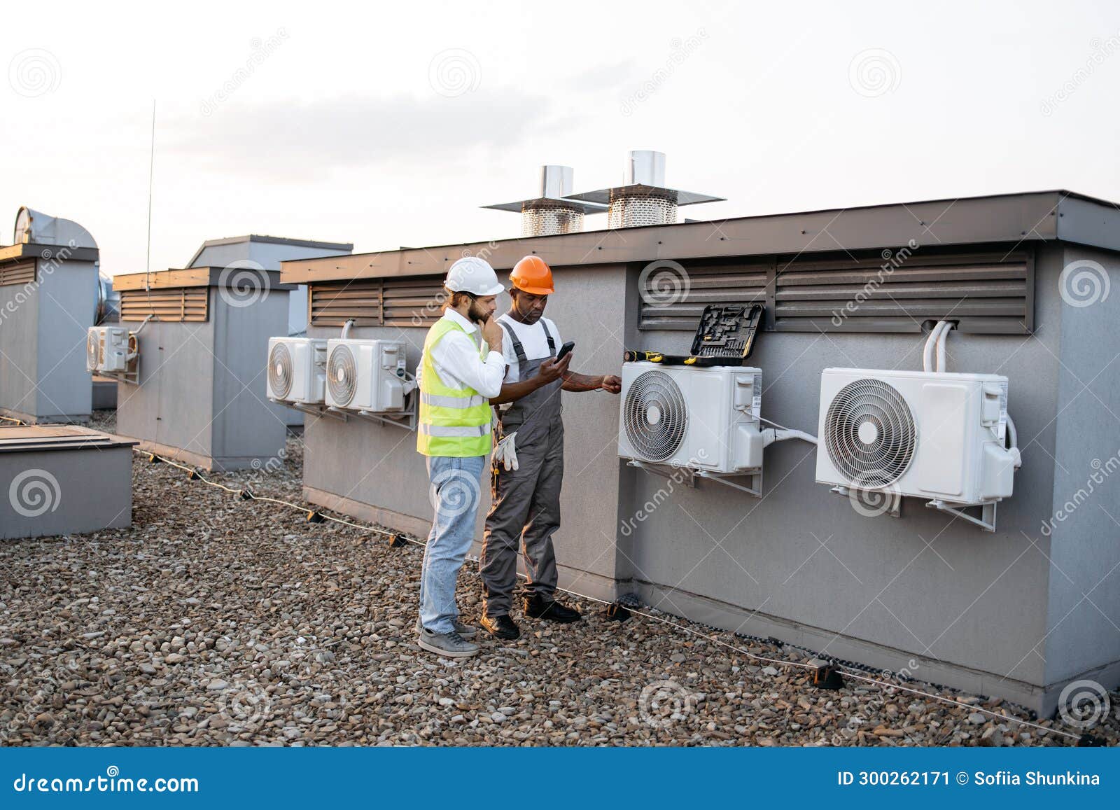 Two Construction Workers on Roof Inspecting Cooling System Stock Image Image of vest, pipes