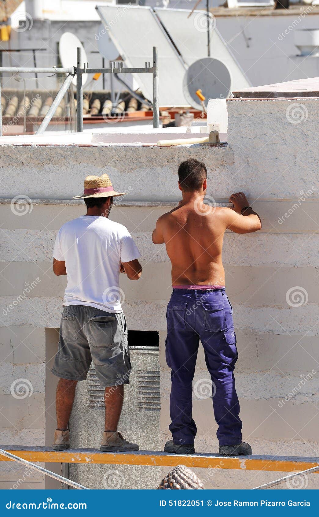 Two Construction Workers Working on the Rehabilitation of a House