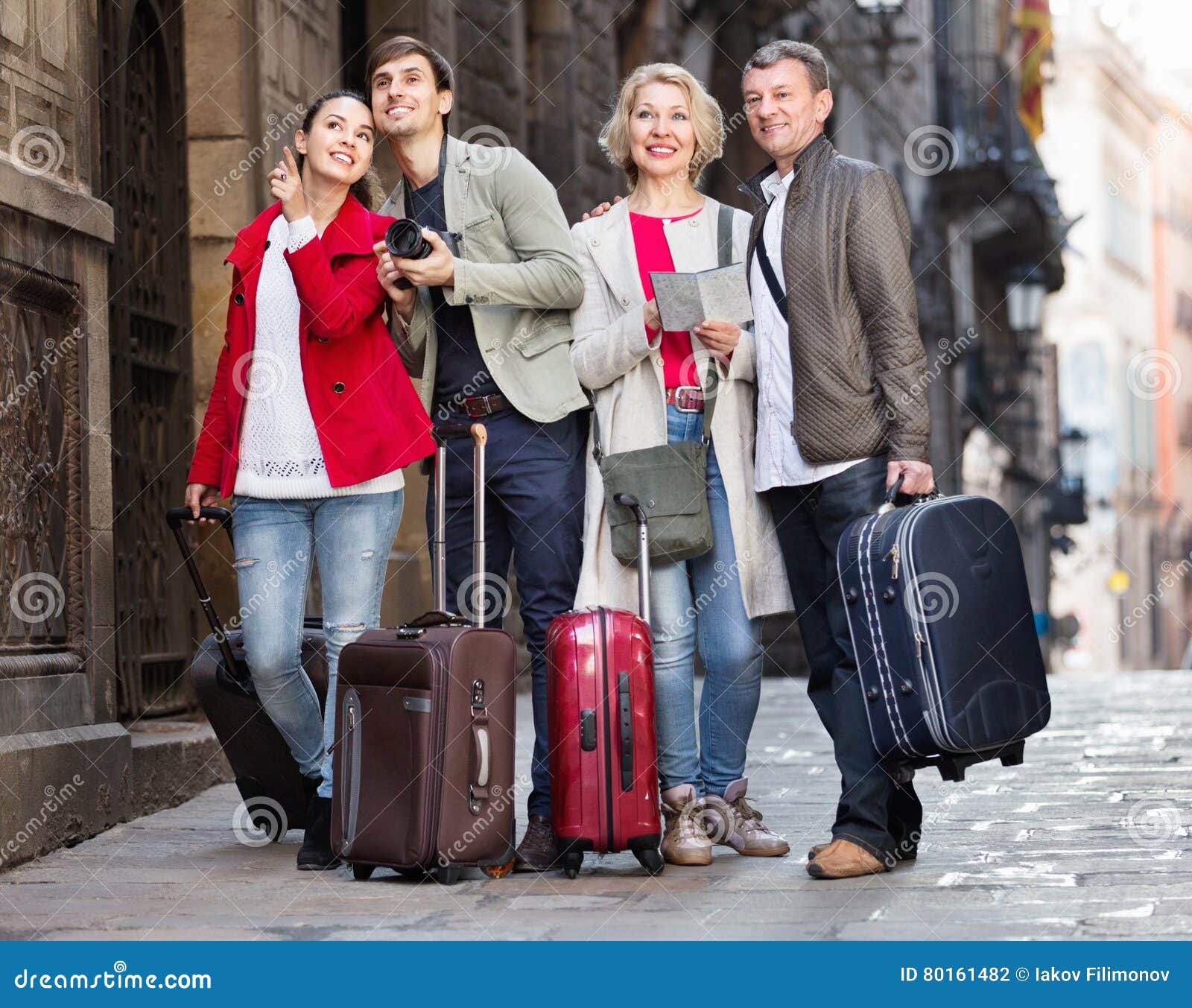 Two Couples with Luggage Search for Sights on Map Stock Photo Image