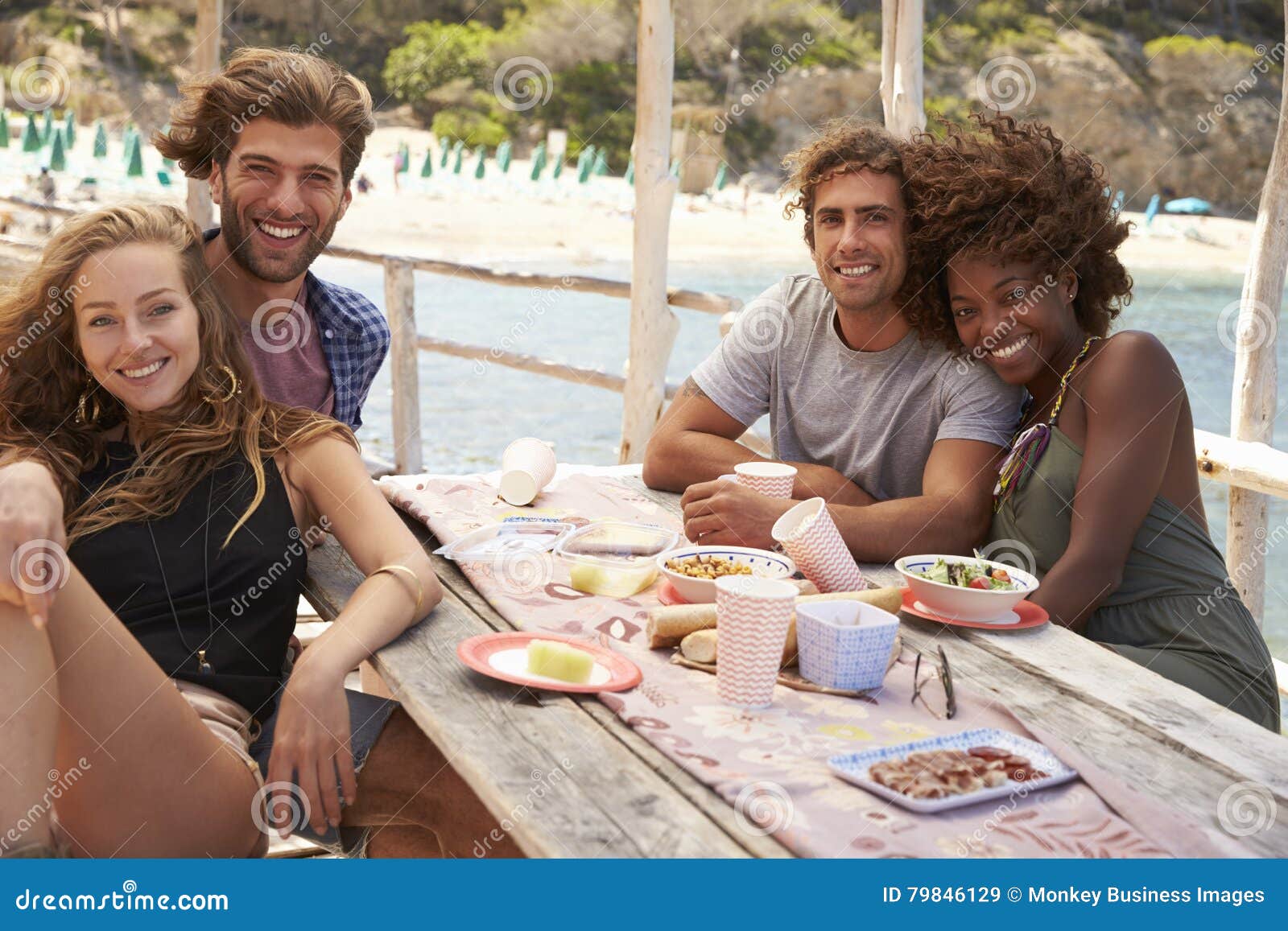 Two Couples Sitting Together At A Table By The Sea, Stock Image