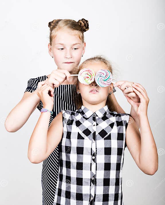 Two Cute Little Girlfriend Eating Bright Lollipops. Funny Kids Stock ...