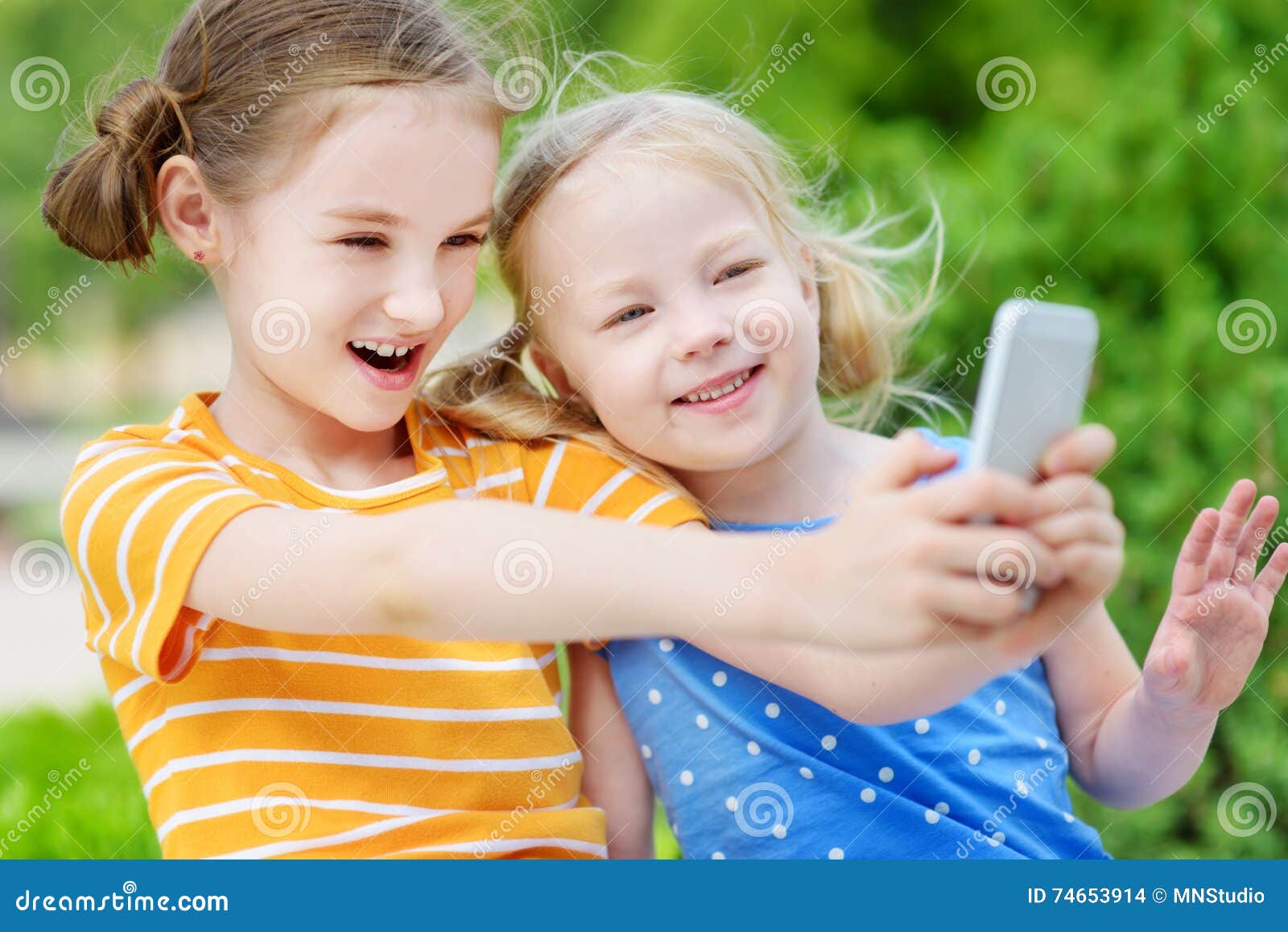 Two Cute Little Sisters Playing Outdoor Mobile Game on Their Smart ...