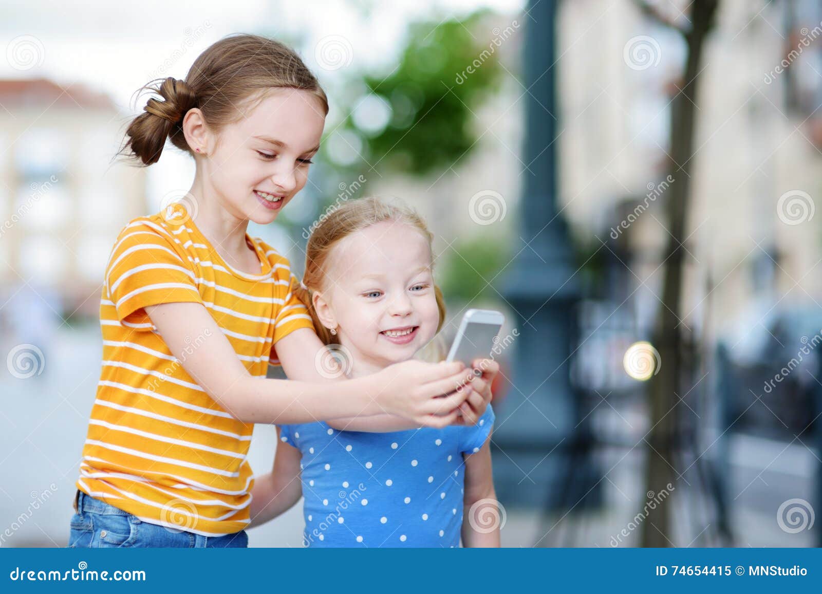 Two Cute Little Sisters Playing Outdoor Mobile Game on Their Smart ...