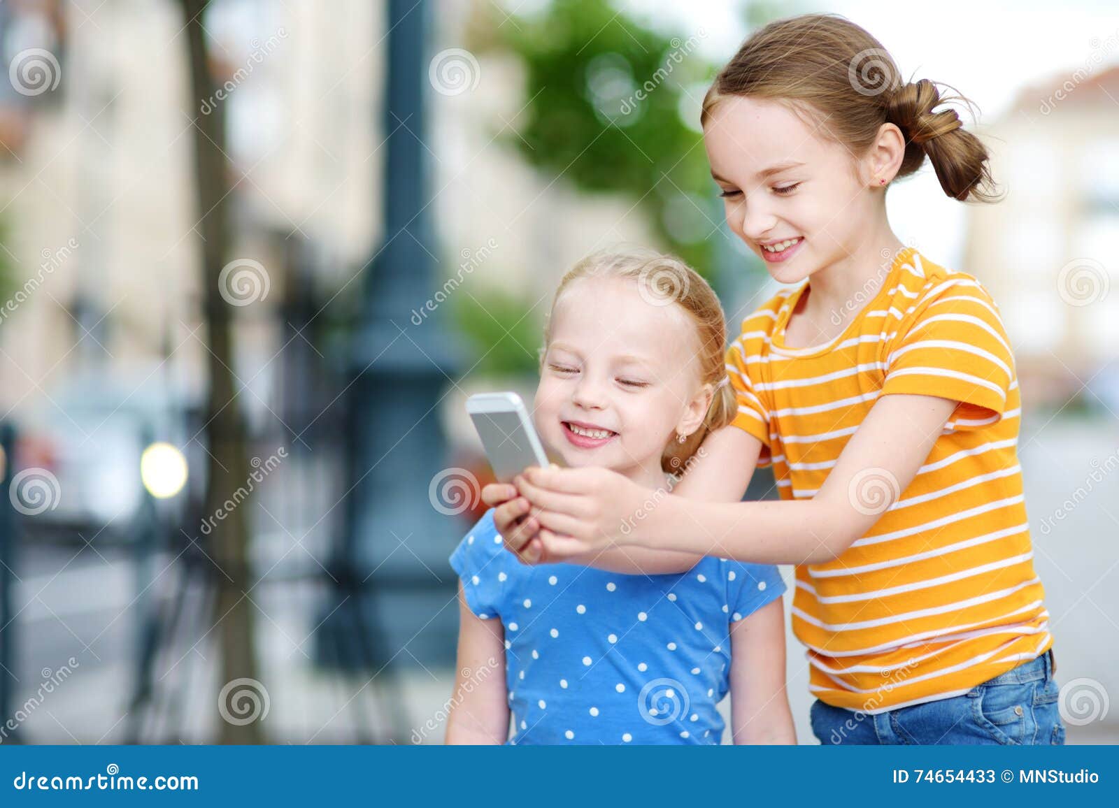 Two Cute Little Sisters Playing Outdoor Mobile Game on Their Smart ...