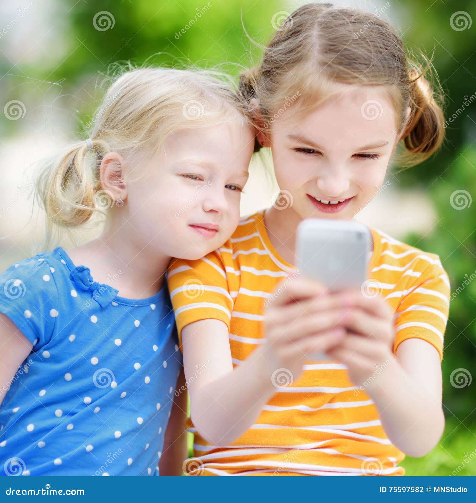 Two Cute Little Sisters Playing Outdoor Mobile Game on Their Smart ...