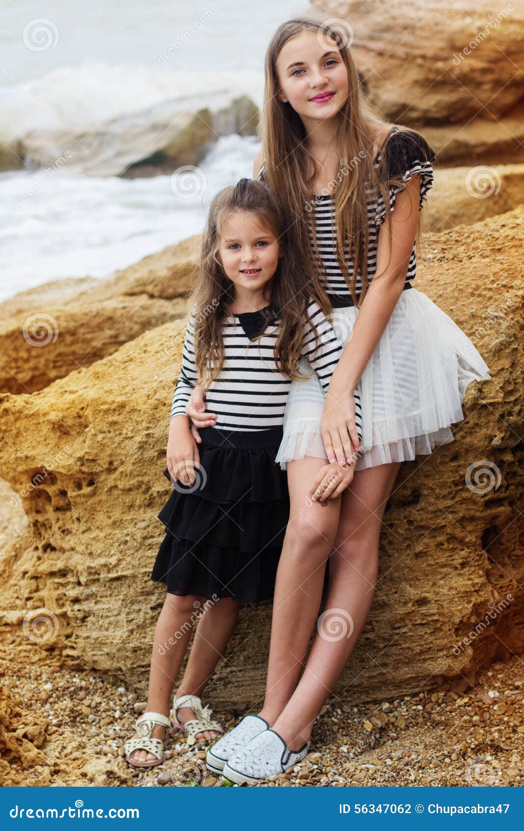 Young women wearing summer trendy outfits walking on the beach. Stock Photo  by ansiia