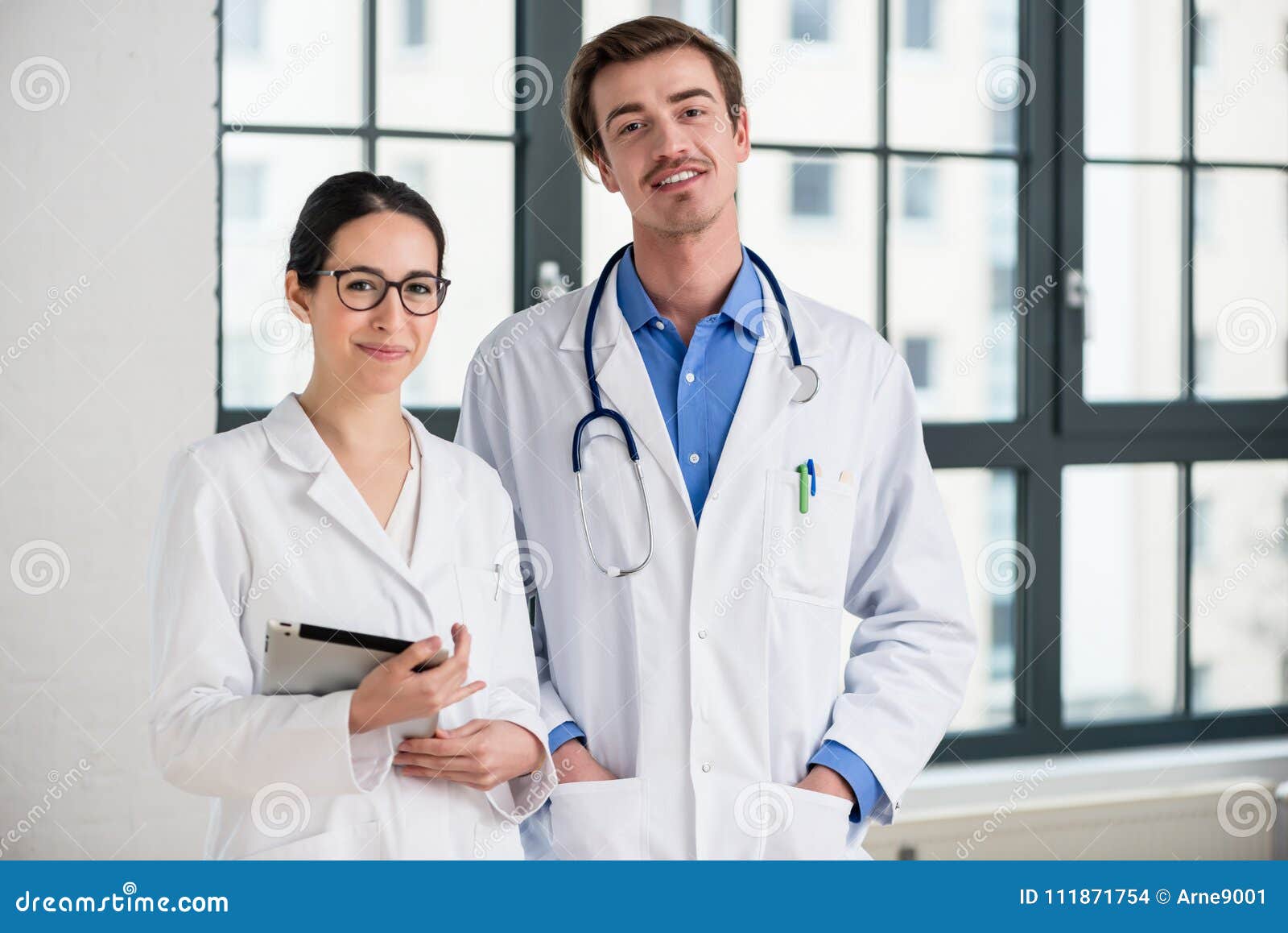 two dedicated doctors smiling at camera