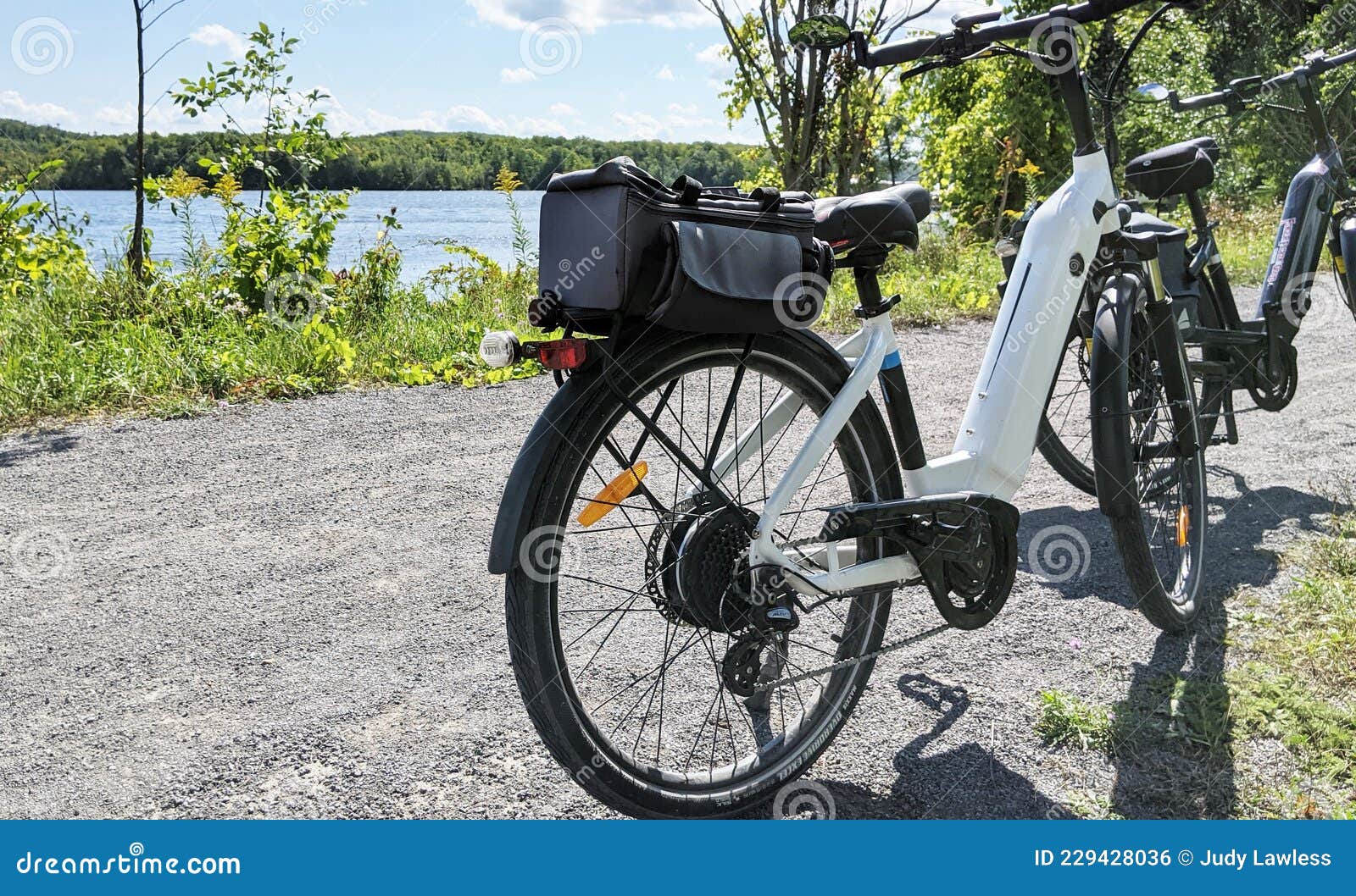 two e-bikes on a trail beside a river