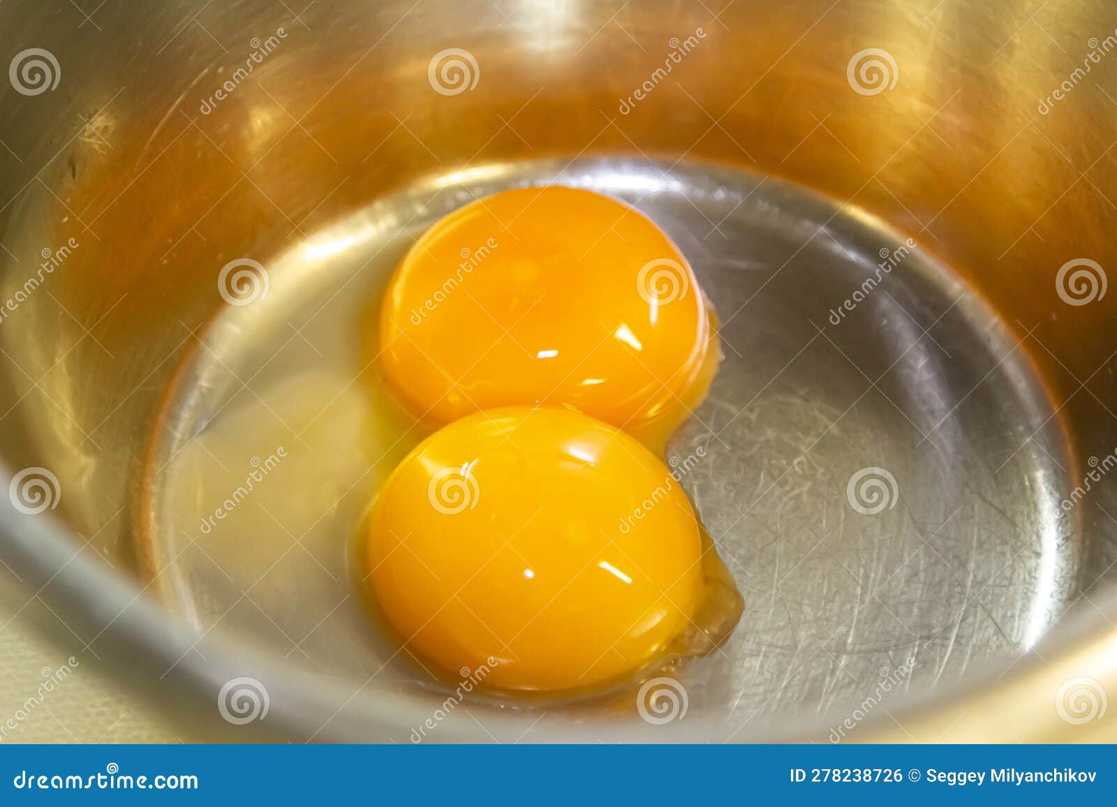 Two Egg Yolks in a Steel Bowl for Making Sauce or Omelet Stock Photo