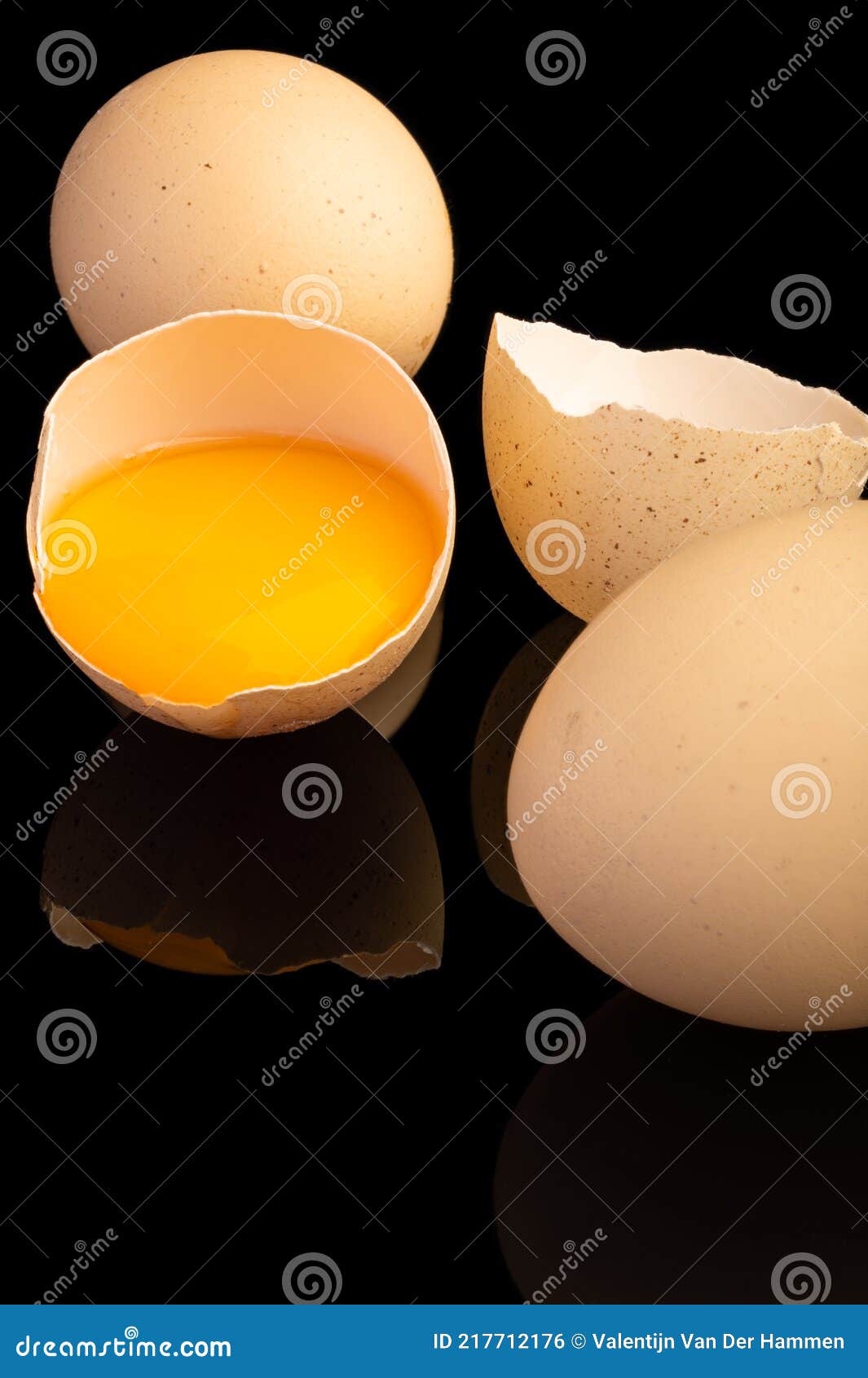 Two Eggs and a Broken Egg with Yellow or Orange Egg Yolk in the Shell