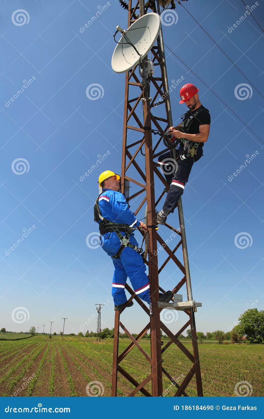 Two Electricians are Working on Power Transmission Line Stock Photo
